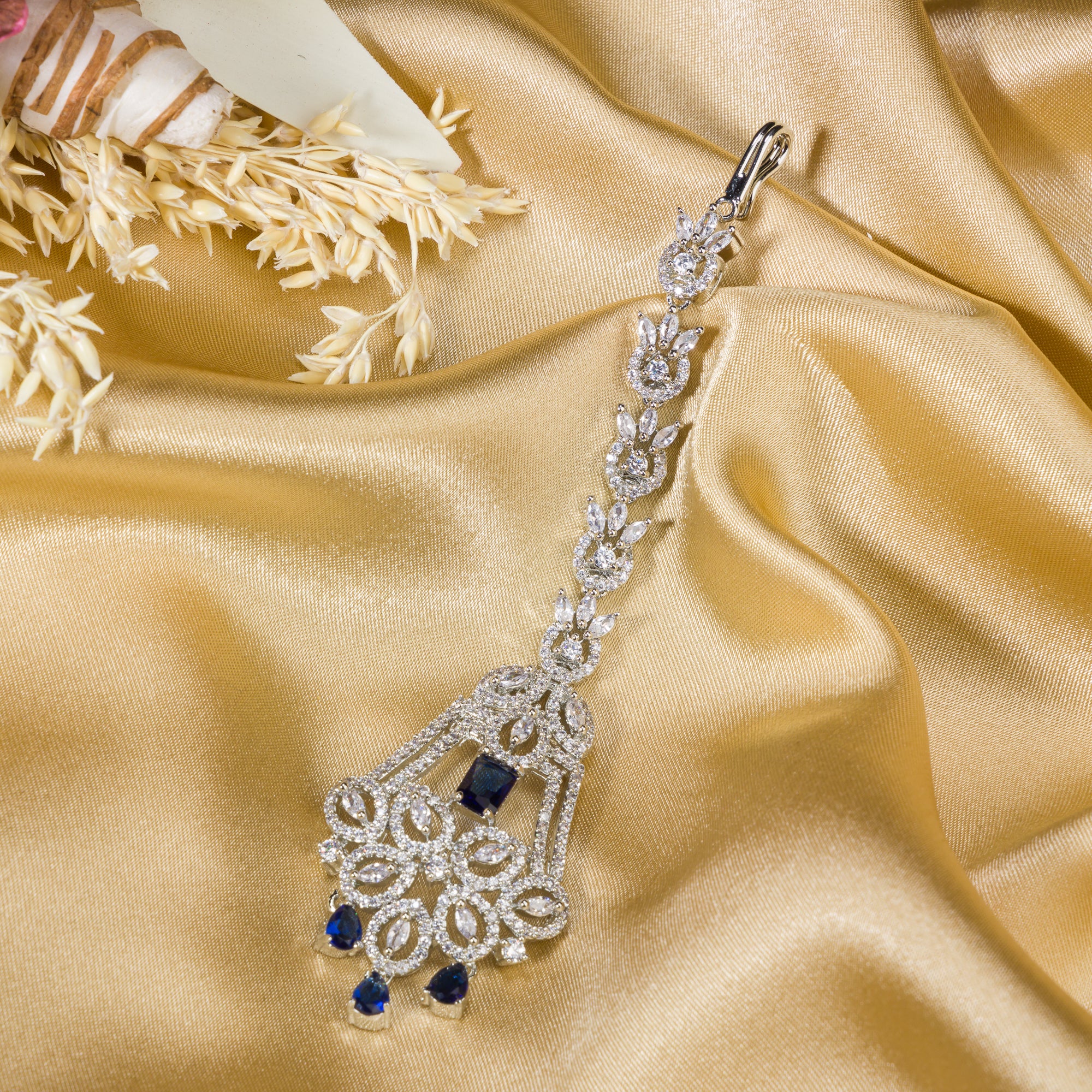 Blue zircon maang tika in silver, ideal for party wear, offering a striking touch of vibrant elegance.