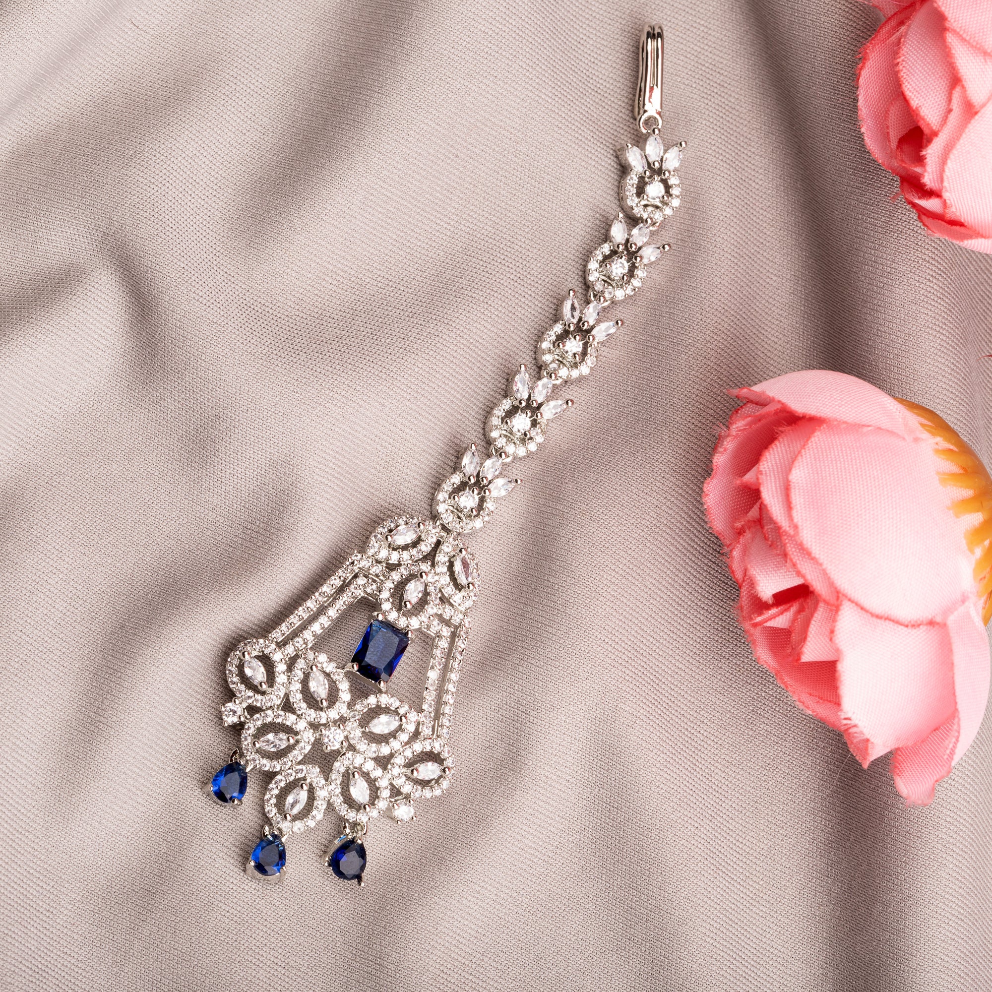 Blue zircon maang tika in silver, ideal for party wear, offering a striking touch of vibrant elegance.