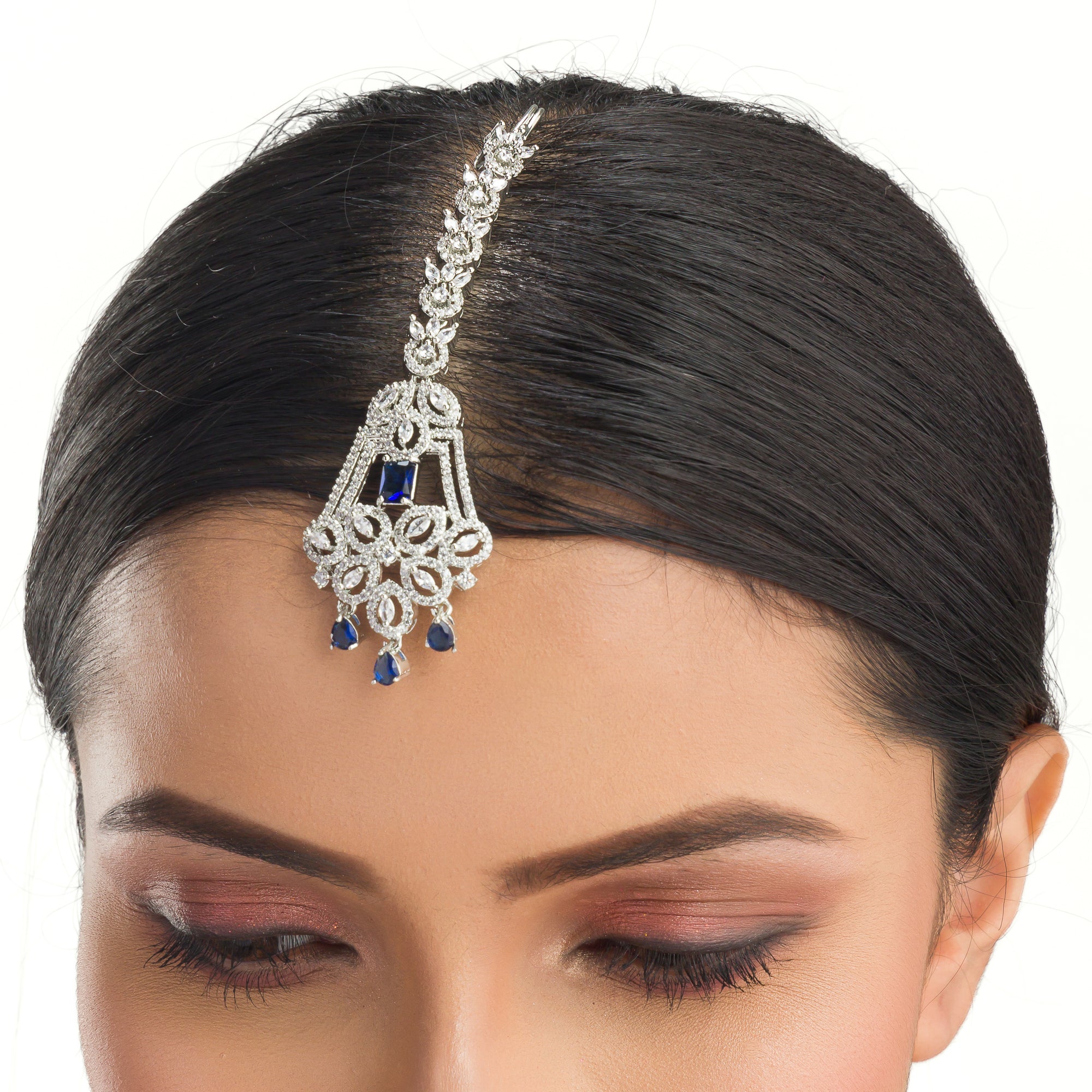 Blue zircon maang tika in silver, ideal for party wear, offering a striking touch of vibrant elegance.
