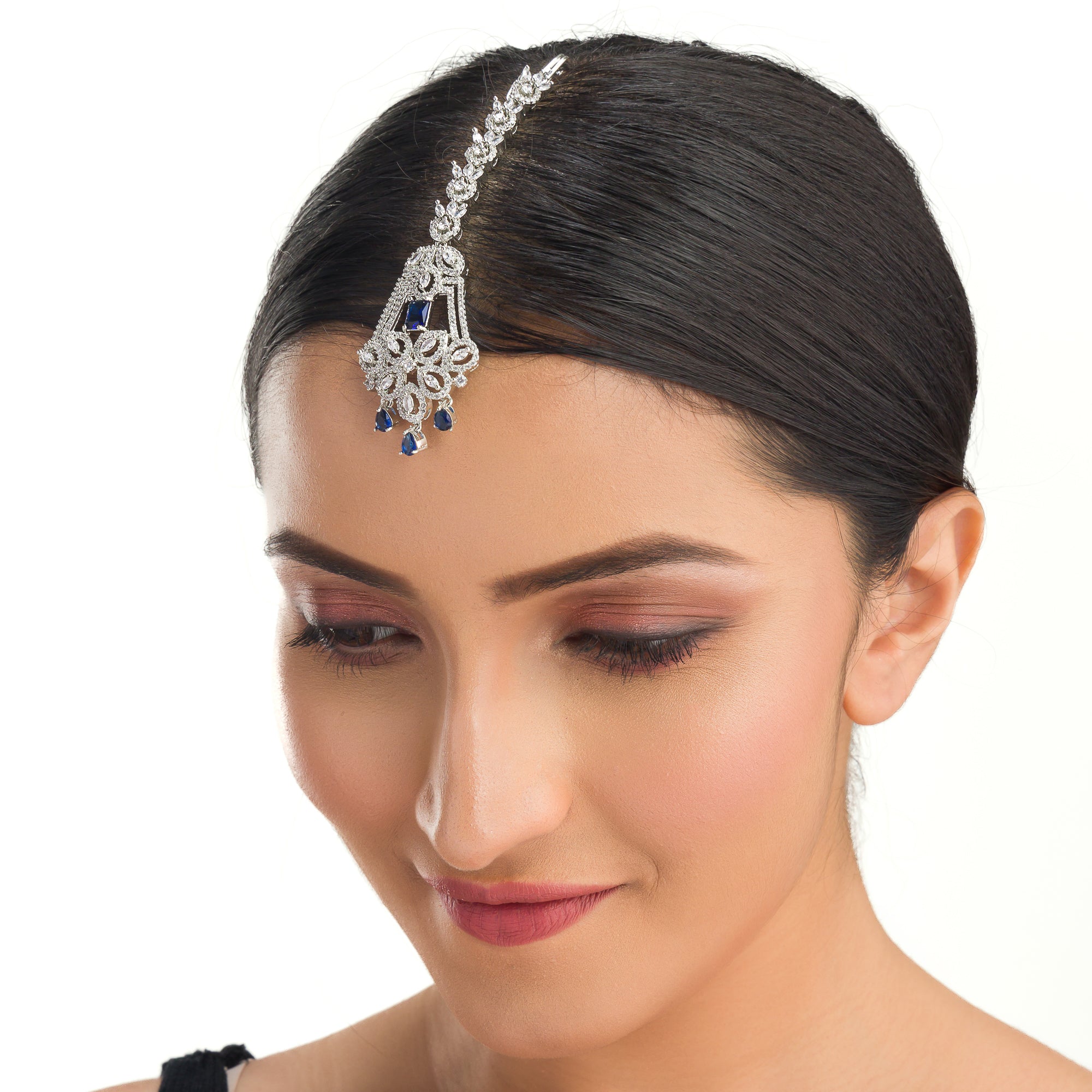 Blue zircon maang tika in silver, ideal for party wear, offering a striking touch of vibrant elegance.