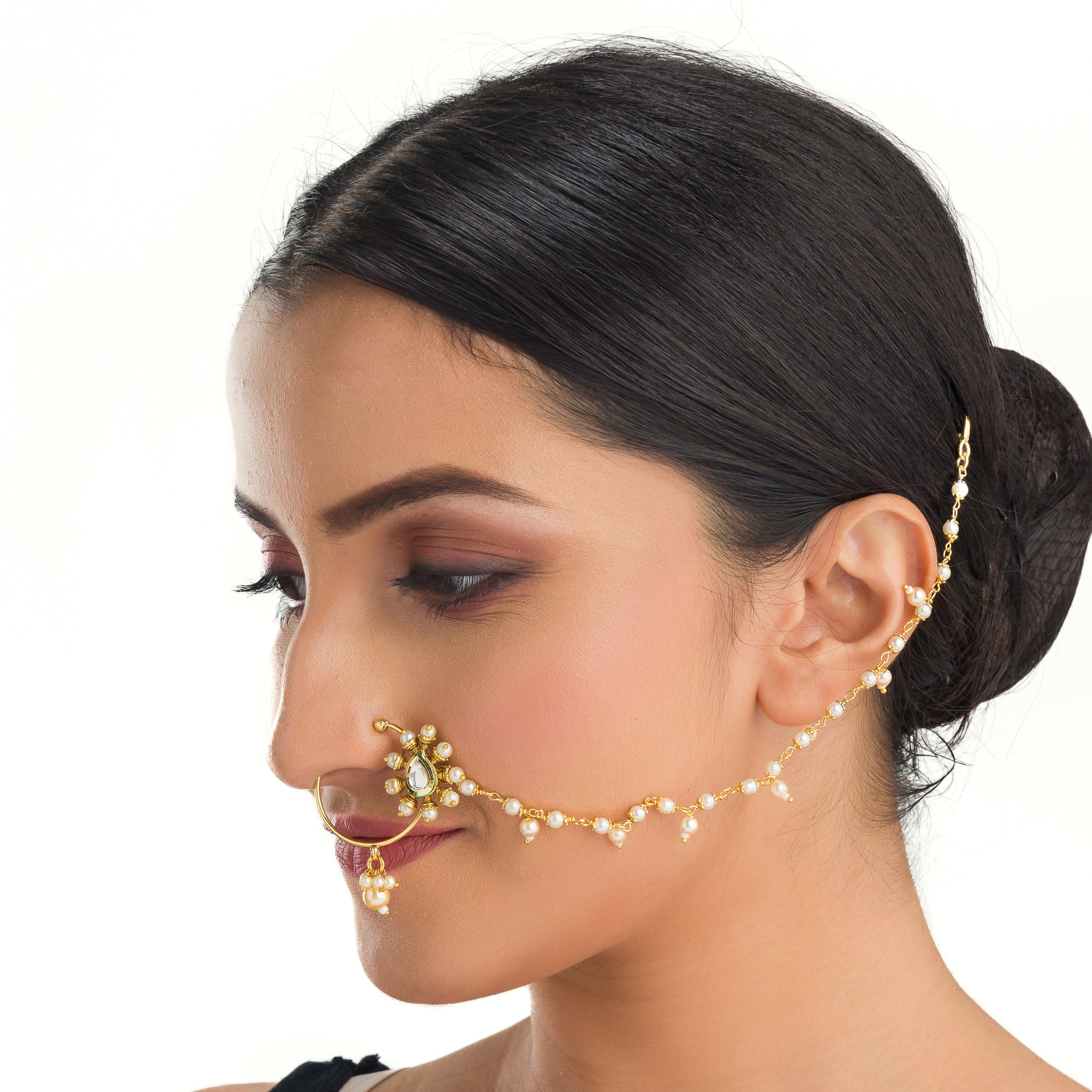"Elegant gold-tone nose pin with pearls, perfect for festival wear, blending tradition and sophistication."