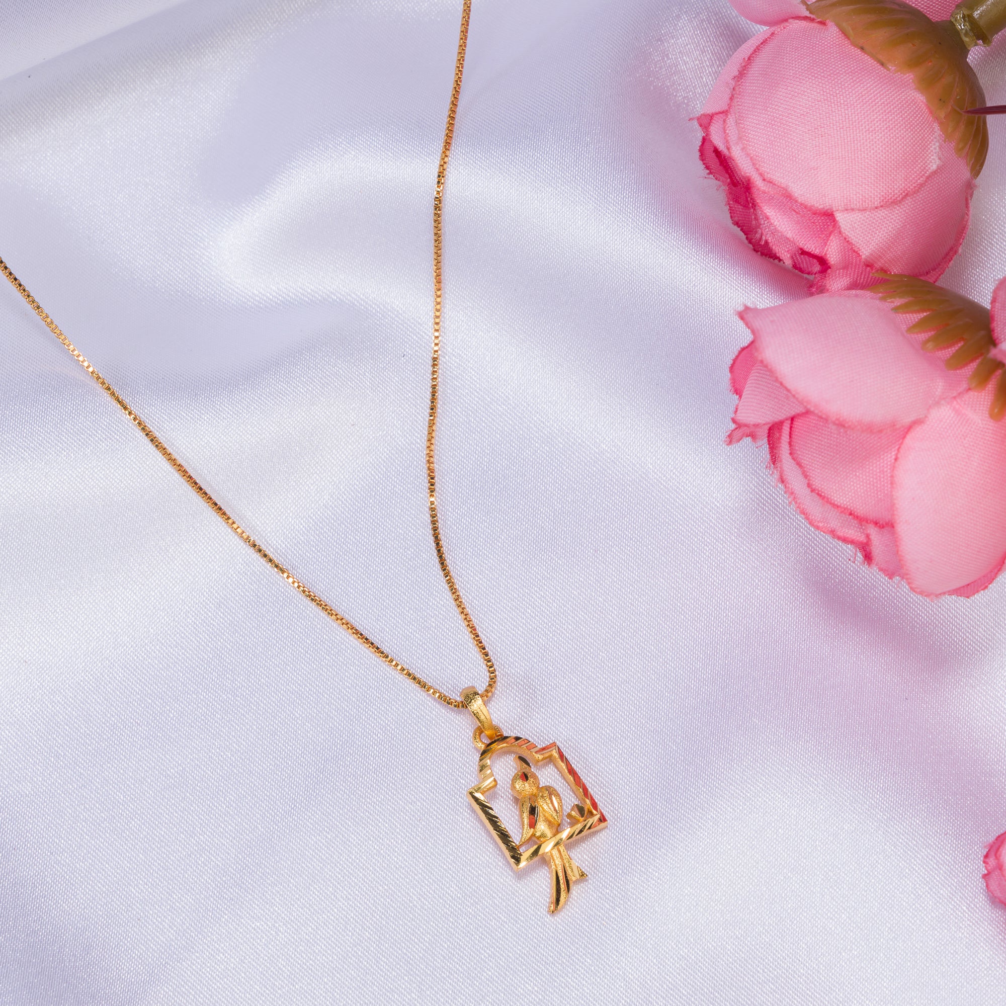 "Charming gold-tone pendant with a bird in a nest, perfect for casual wear, with a warm, elegant finish."