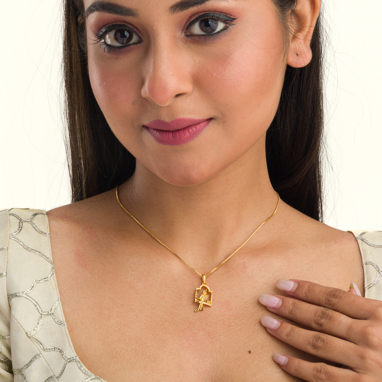 "Charming gold-tone pendant with a bird in a nest, perfect for casual wear, with a warm, elegant finish."