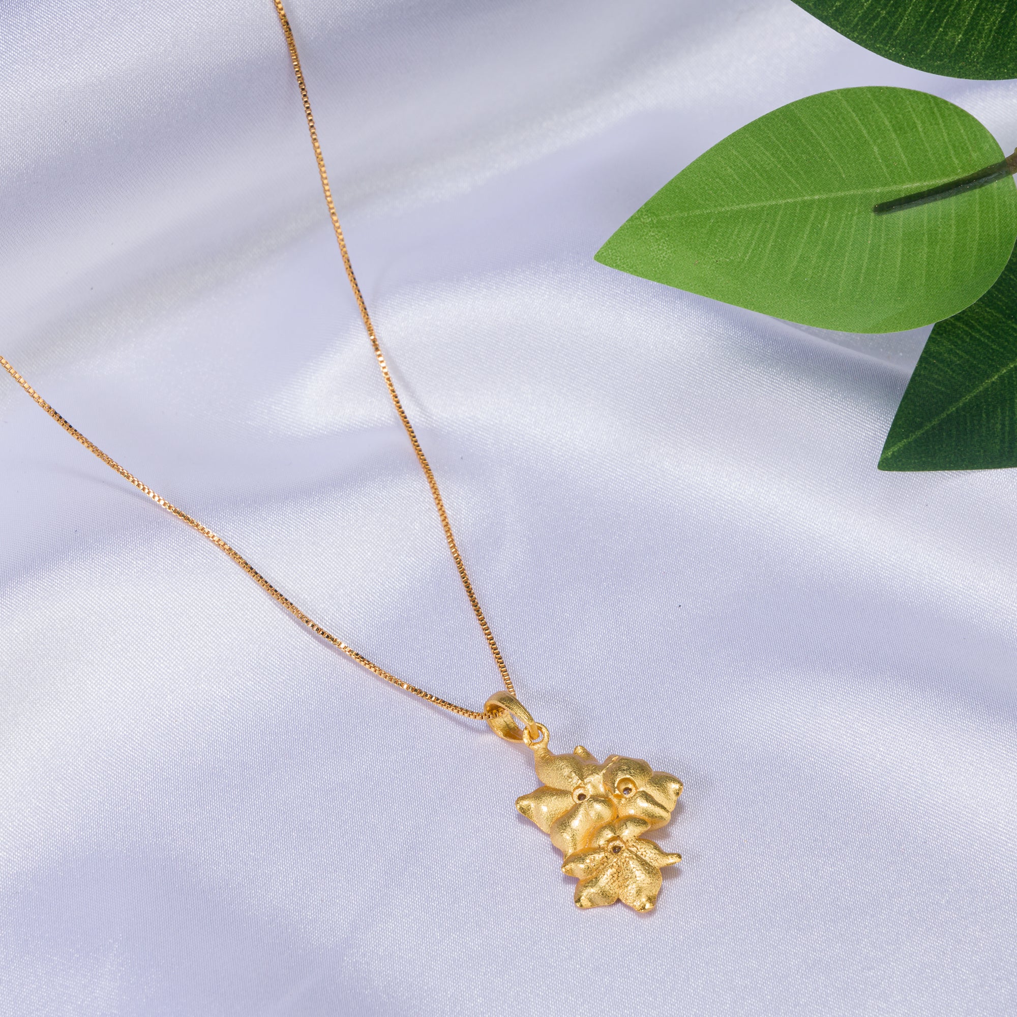 "Gold-tone pendant featuring three flowers, perfect for casual wear, offering a charming, delicate look."