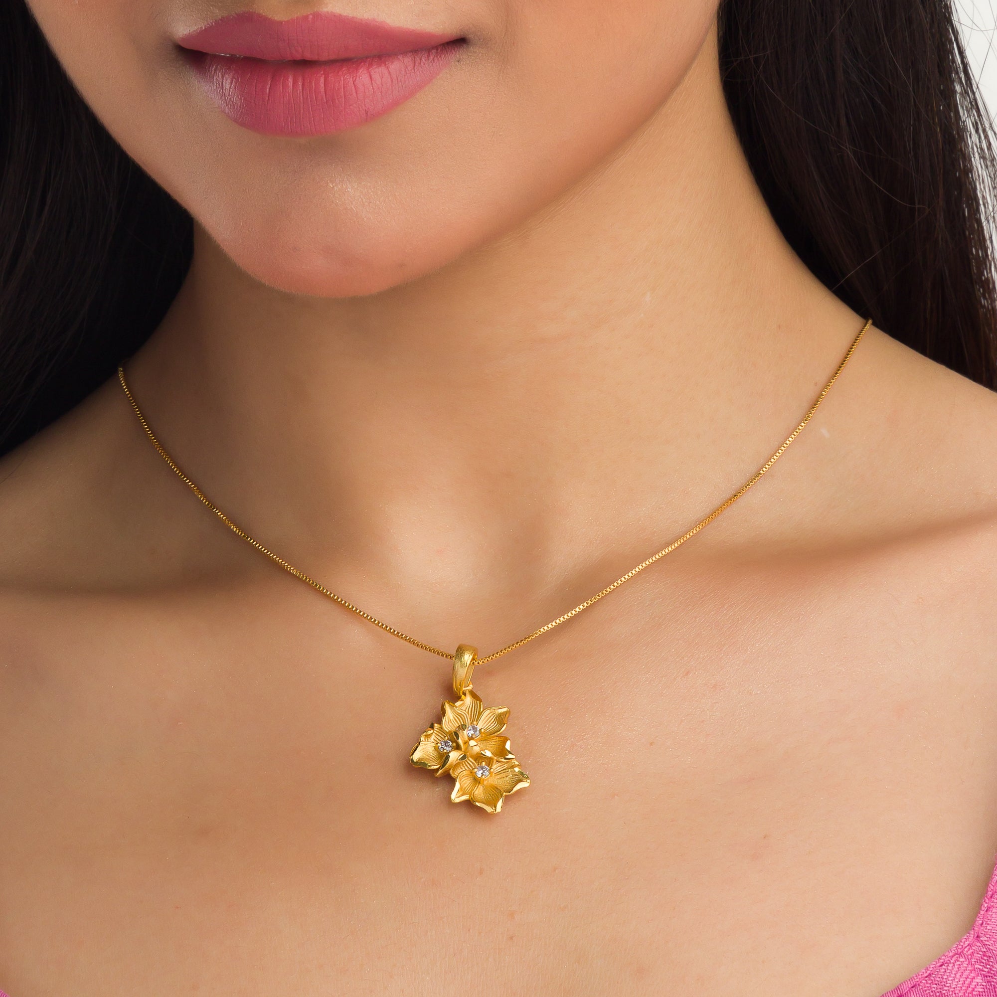 "Gold-tone pendant featuring three flowers, perfect for casual wear, offering a charming, delicate look."