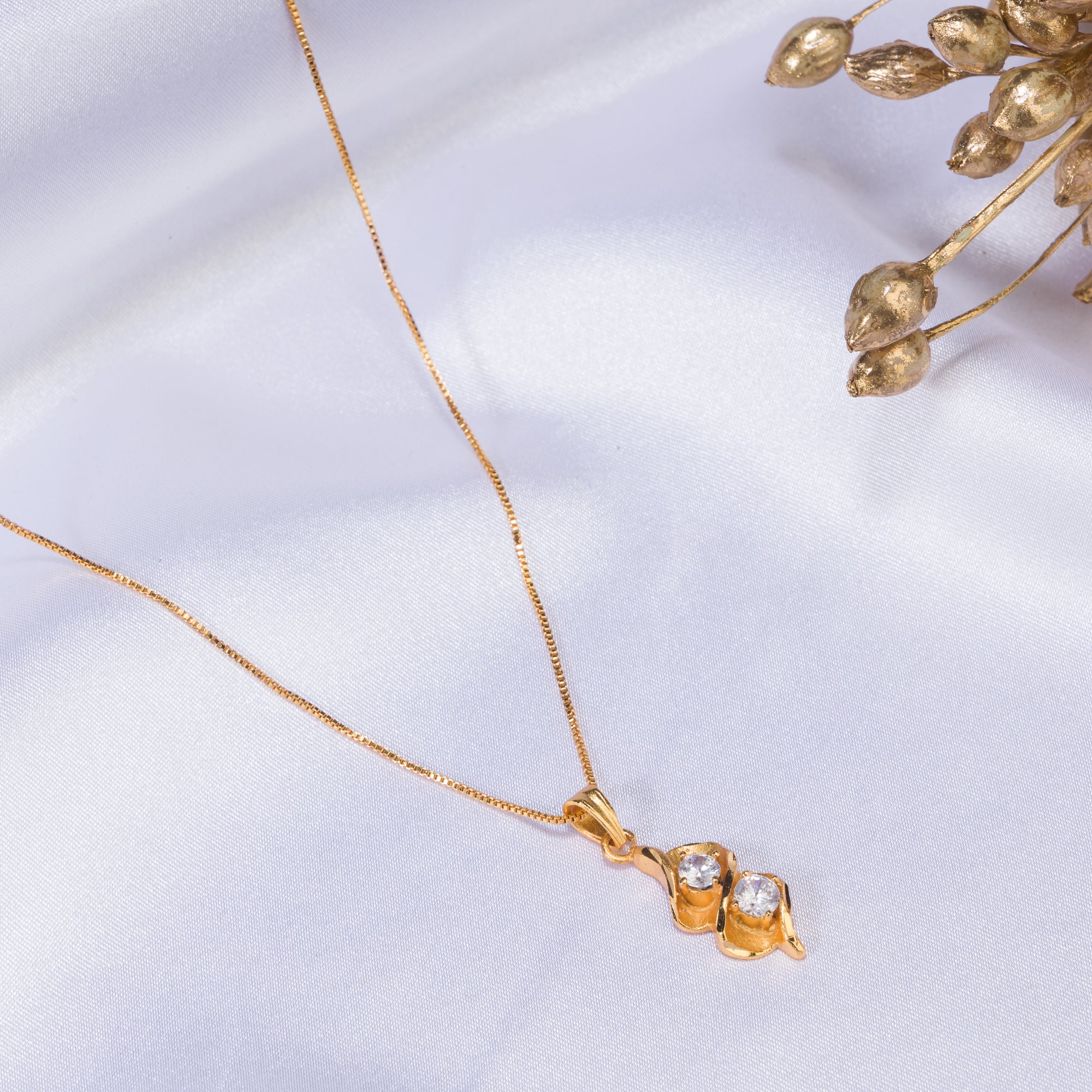 Gold-tone pendant in infinity shape with two stones, perfect for casual wear, adding elegance