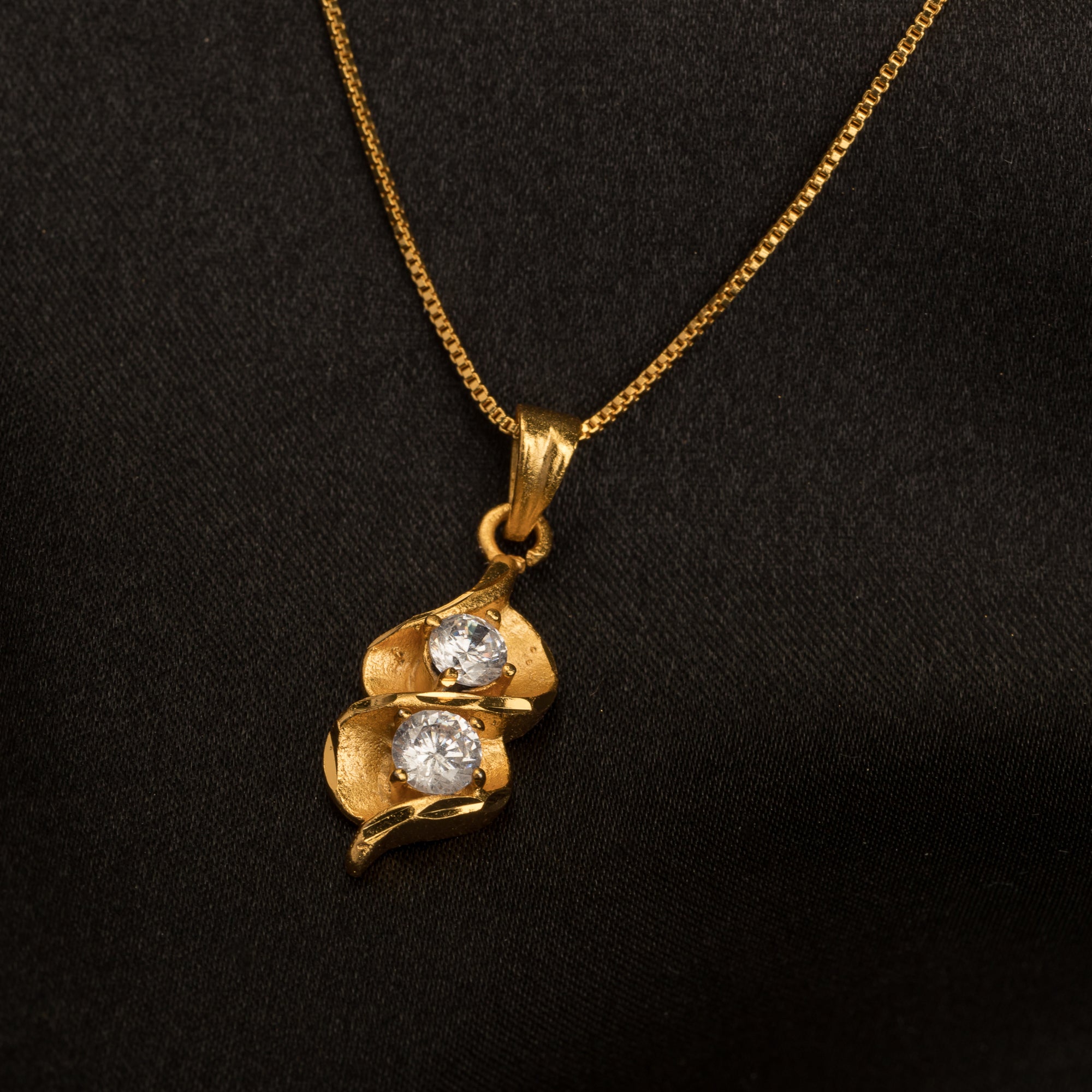 Gold-tone pendant in infinity shape with two stones, perfect for casual wear, adding elegance