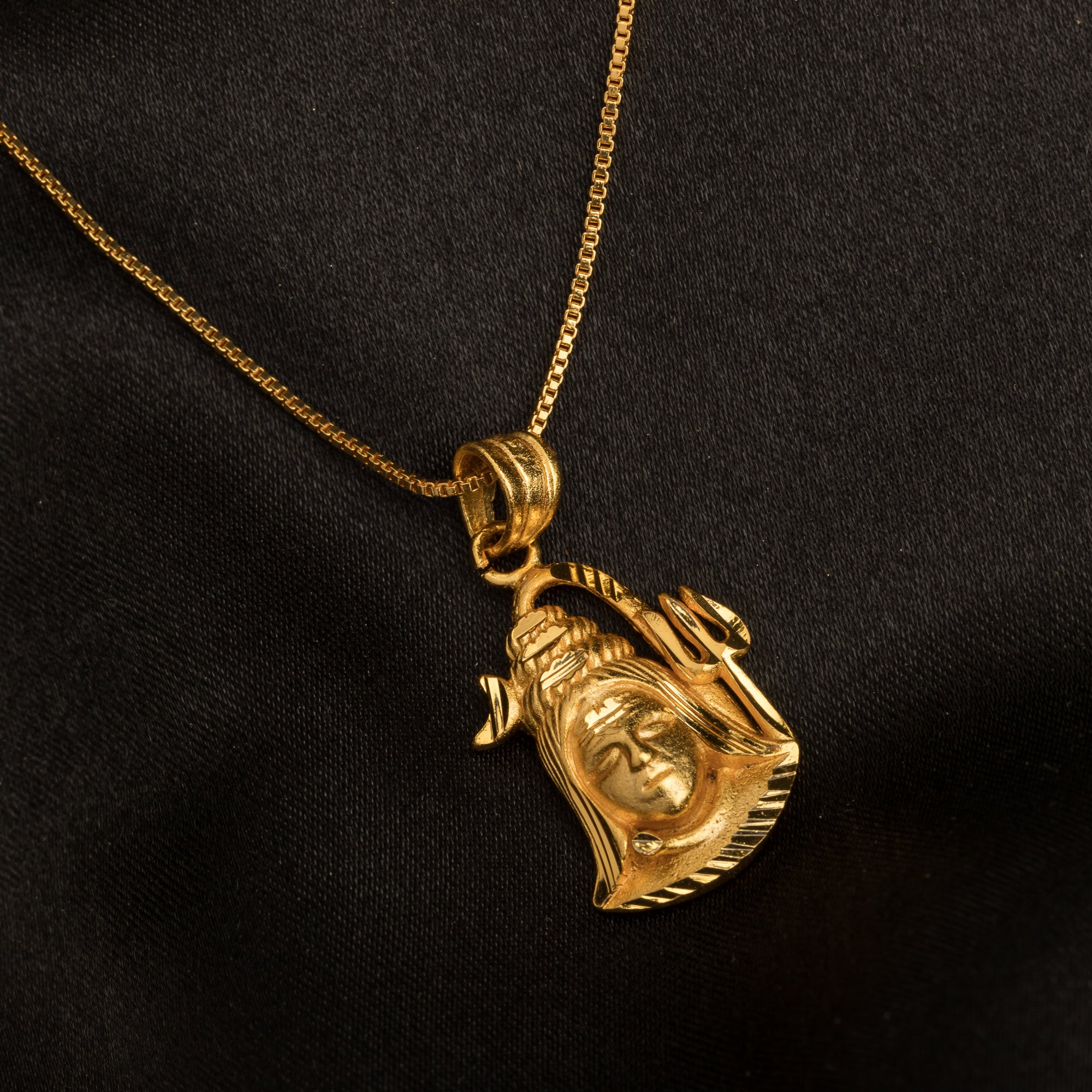 "Gold-tone pendant set featuring Shivji with half moon and trishul, perfect for casual wear."