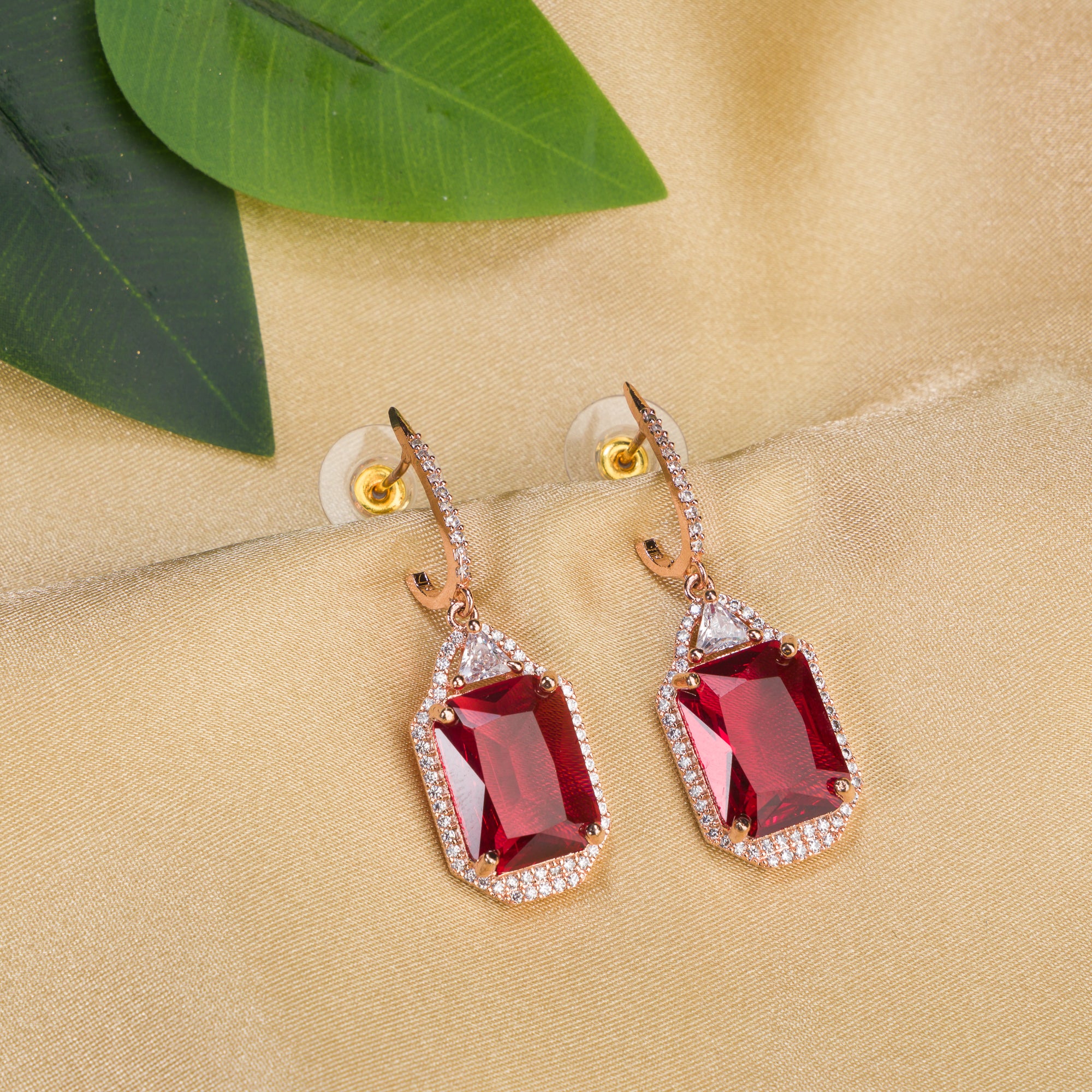 "Dark red zircon dangler earrings in rose gold offer a bold, sophisticated touch for party wear."