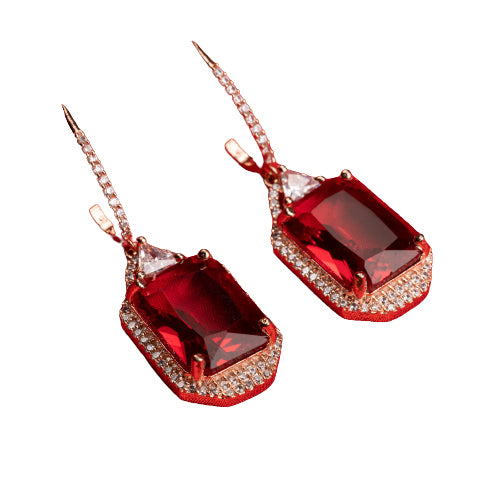 "Dark red zircon dangler earrings in rose gold offer a bold, sophisticated touch for party wear."