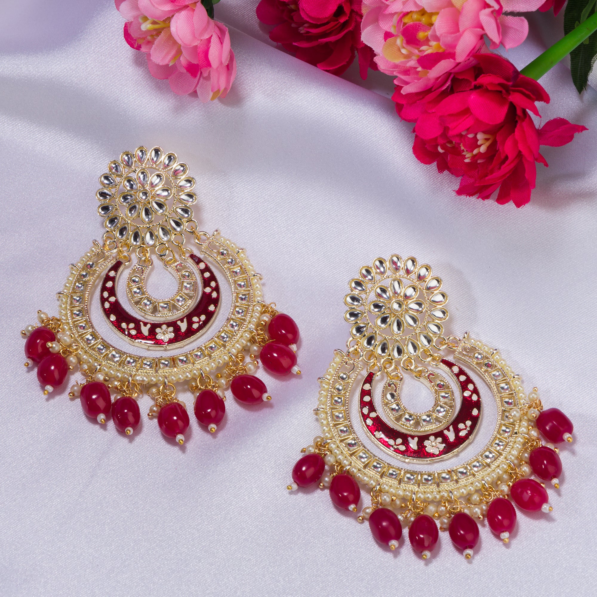 1. "Red kundan dangler earrings in gold add a vibrant touch to your festive look. Perfect for celebrations."