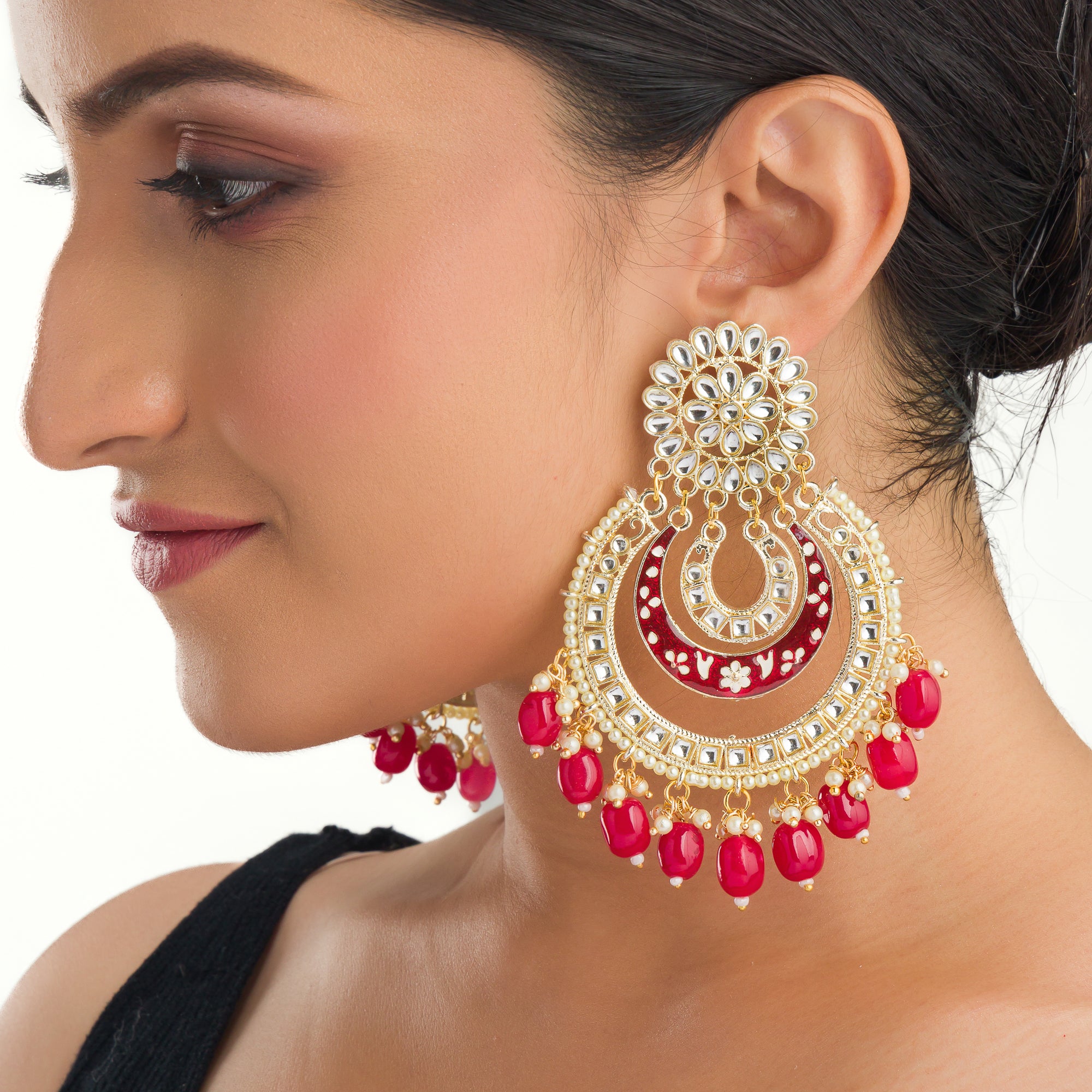 "Red kundan dangler earrings in gold add a vibrant touch to your festive look. Perfect for celebrations."