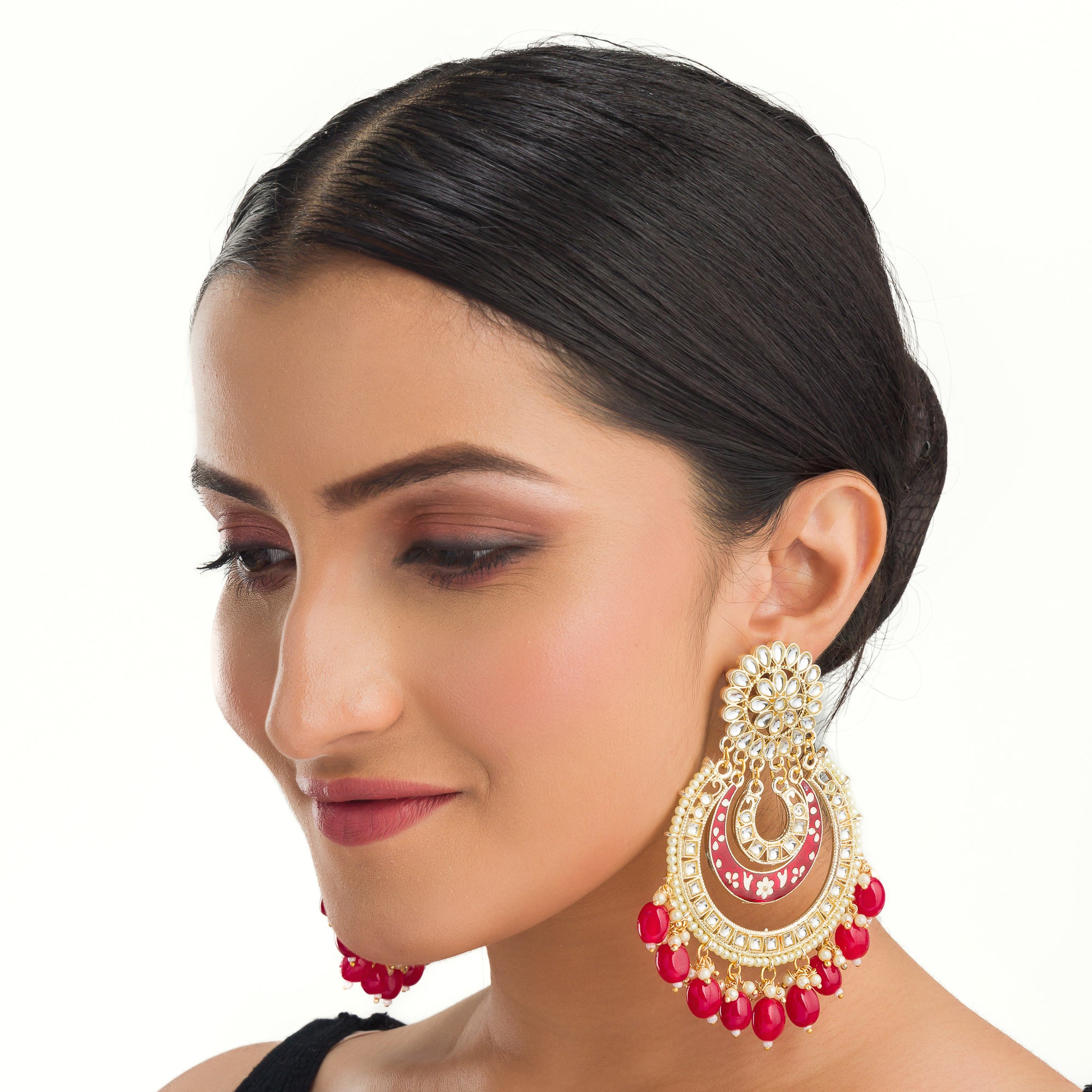 "Red kundan dangler earrings in gold add a vibrant touch to your festive look. Perfect for celebrations."