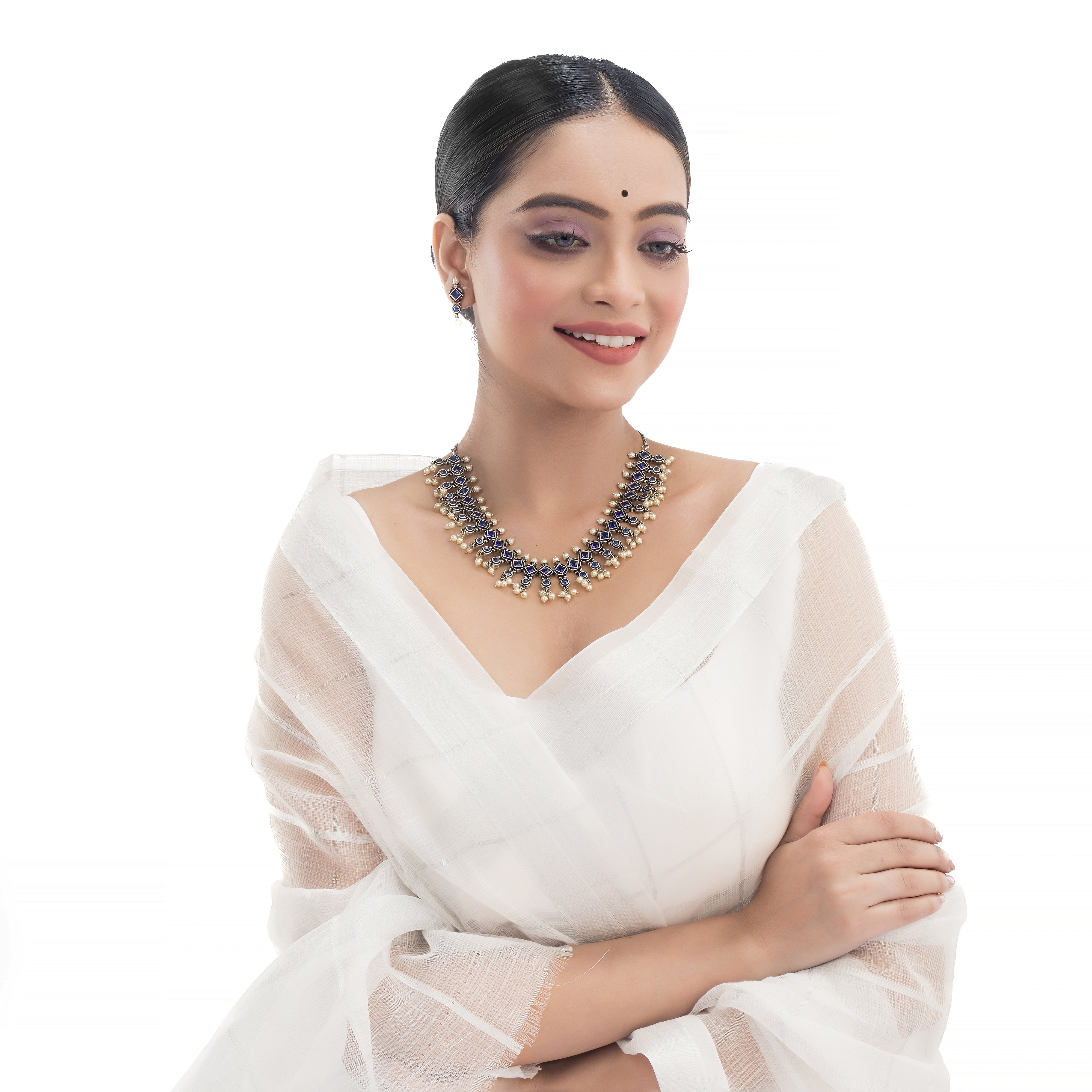 "Zircon stud earrings in silver offer intricate detailing and radiant sparkle for a traditional, elegant party wear look."