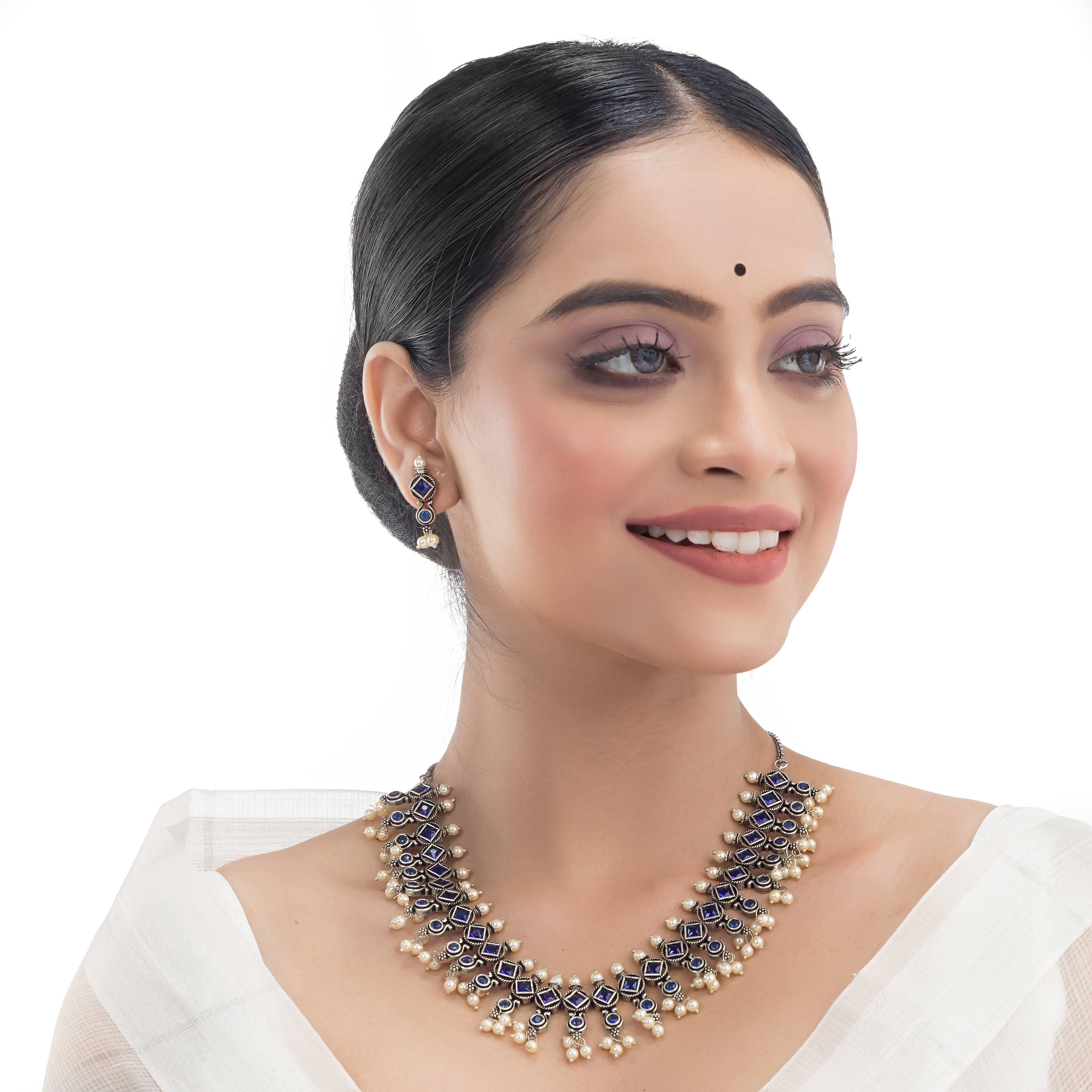 "Zircon stud earrings in silver offer intricate detailing and radiant sparkle for a traditional, elegant party wear look."