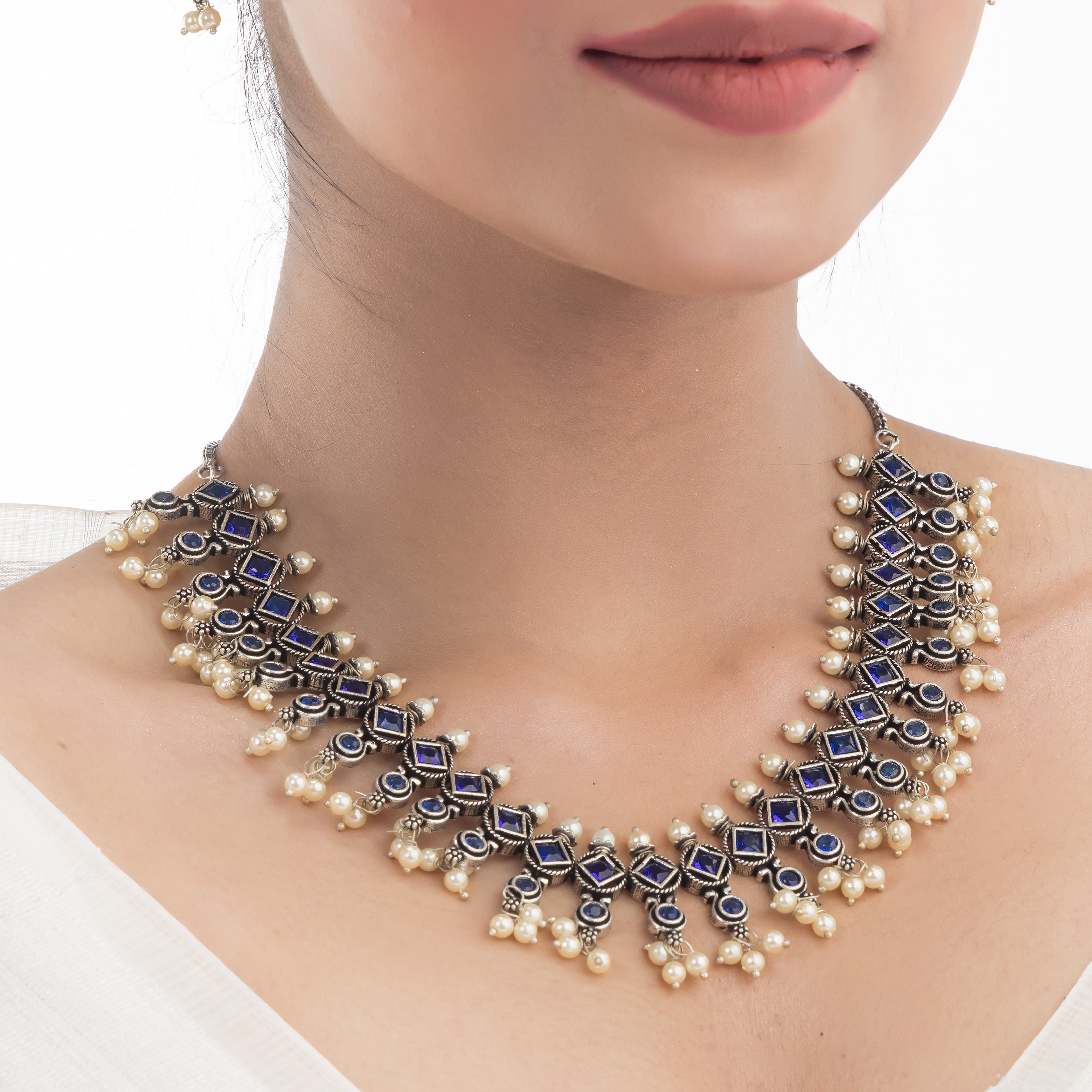 "Zircon stud earrings in silver offer intricate detailing and radiant sparkle for a traditional, elegant party wear look."