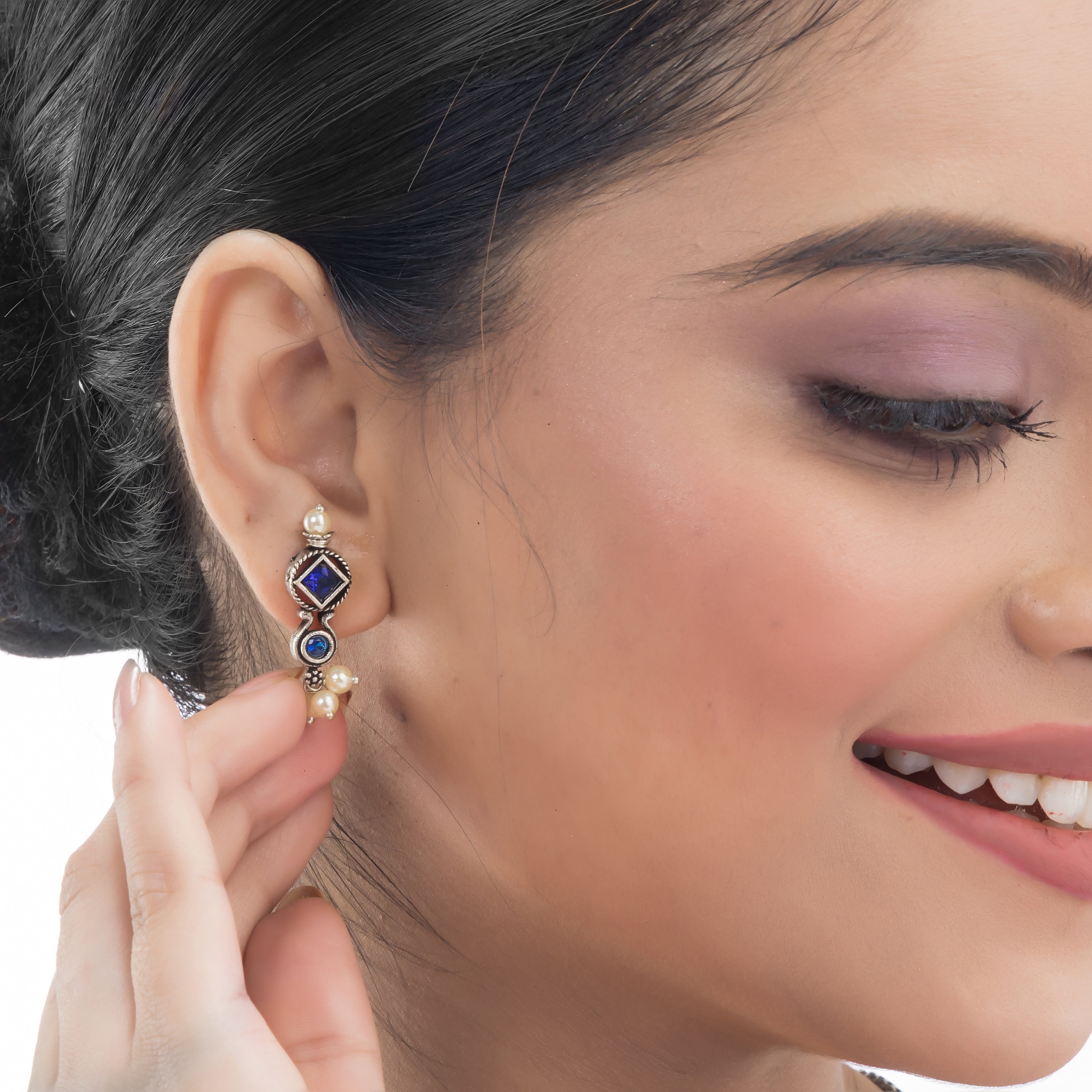 "Zircon stud earrings in silver offer intricate detailing and radiant sparkle for a traditional, elegant party wear look."