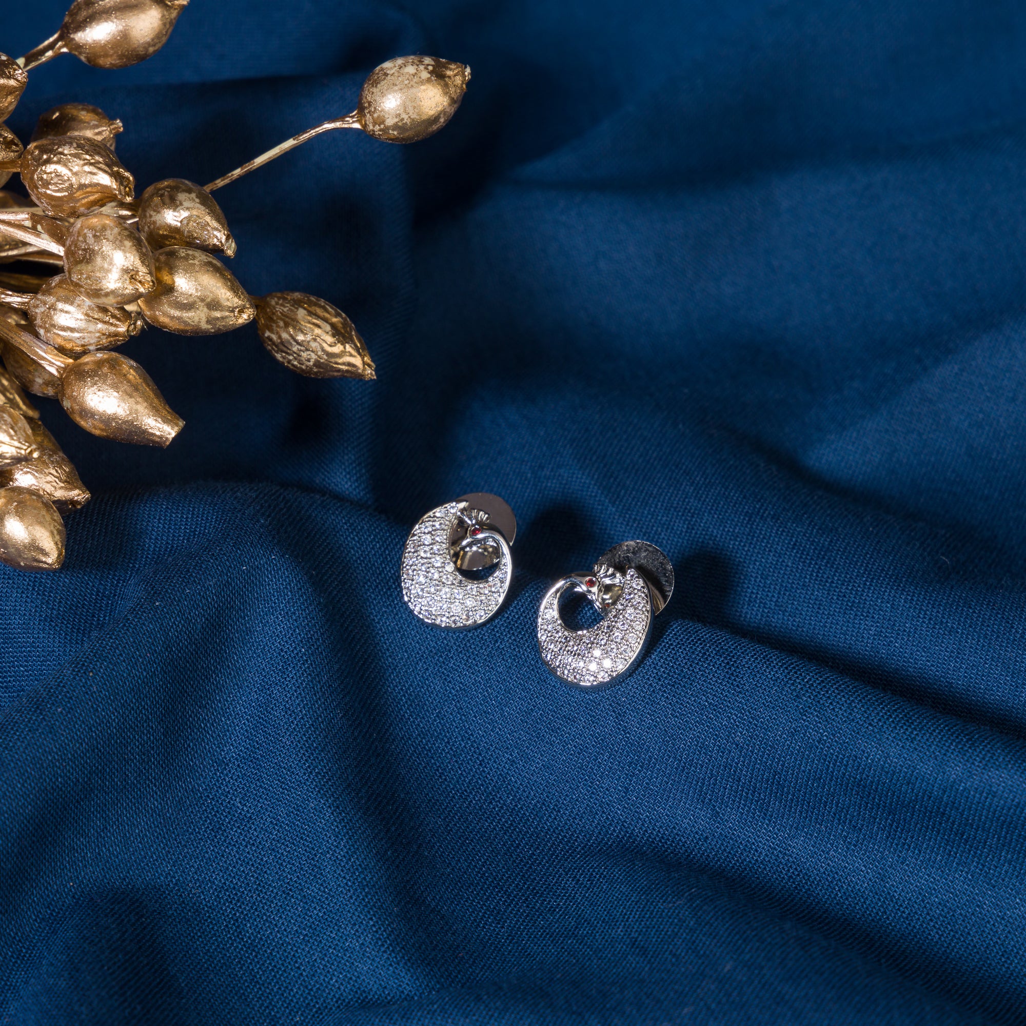 "Elegant peacock-shaped zircon studs add whimsical beauty and sparkle to your look."