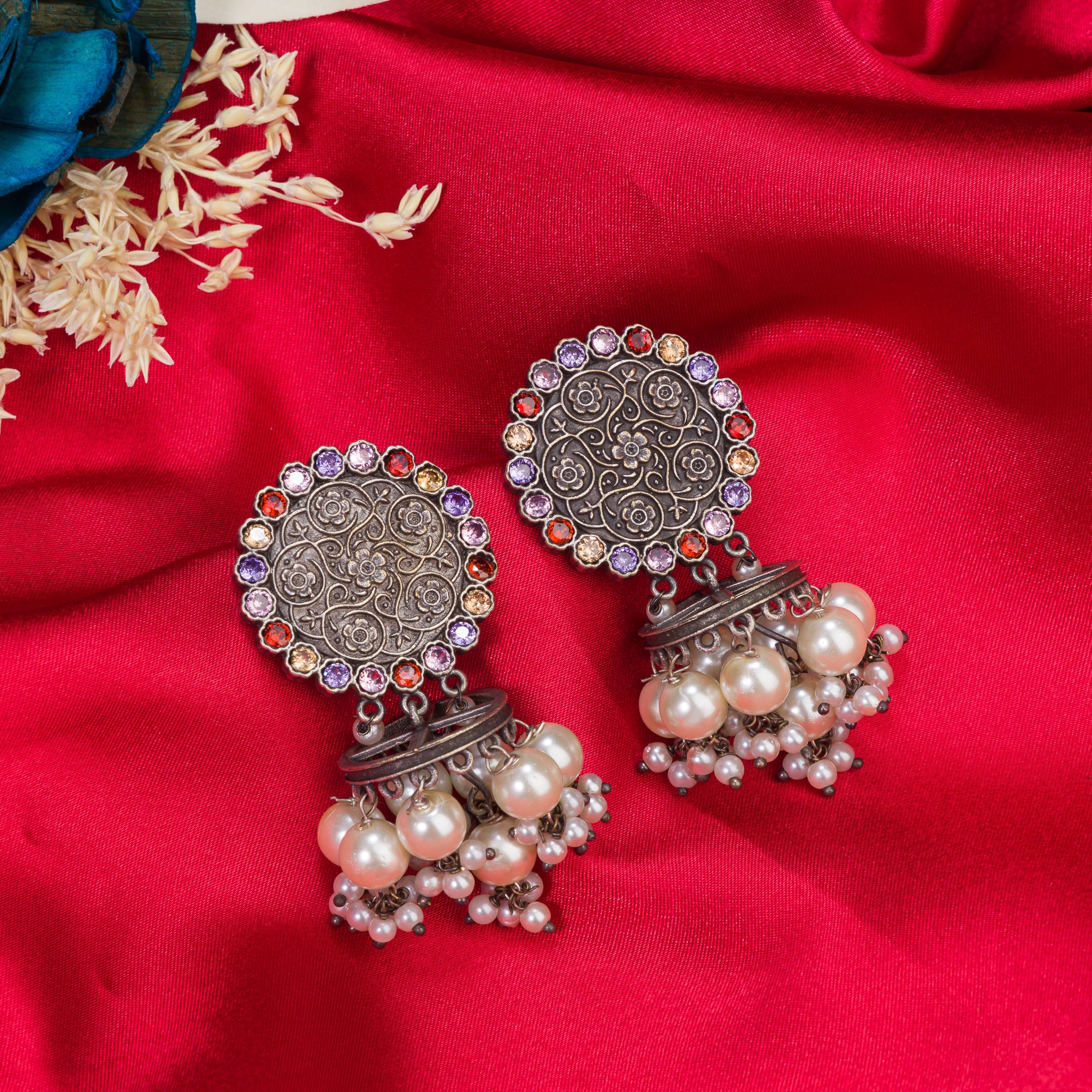 "Oxidized earrings with multi-color stones and pearls add a vibrant, bohemian touch."