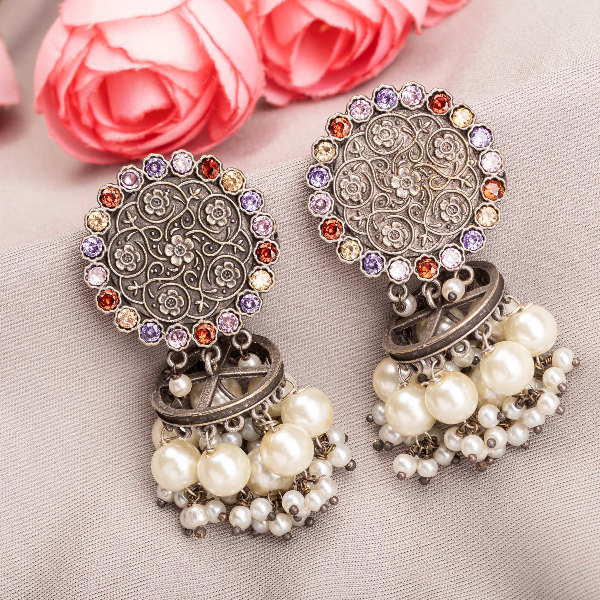"Oxidized earrings with multi-color stones and pearls add a vibrant, bohemian touch."