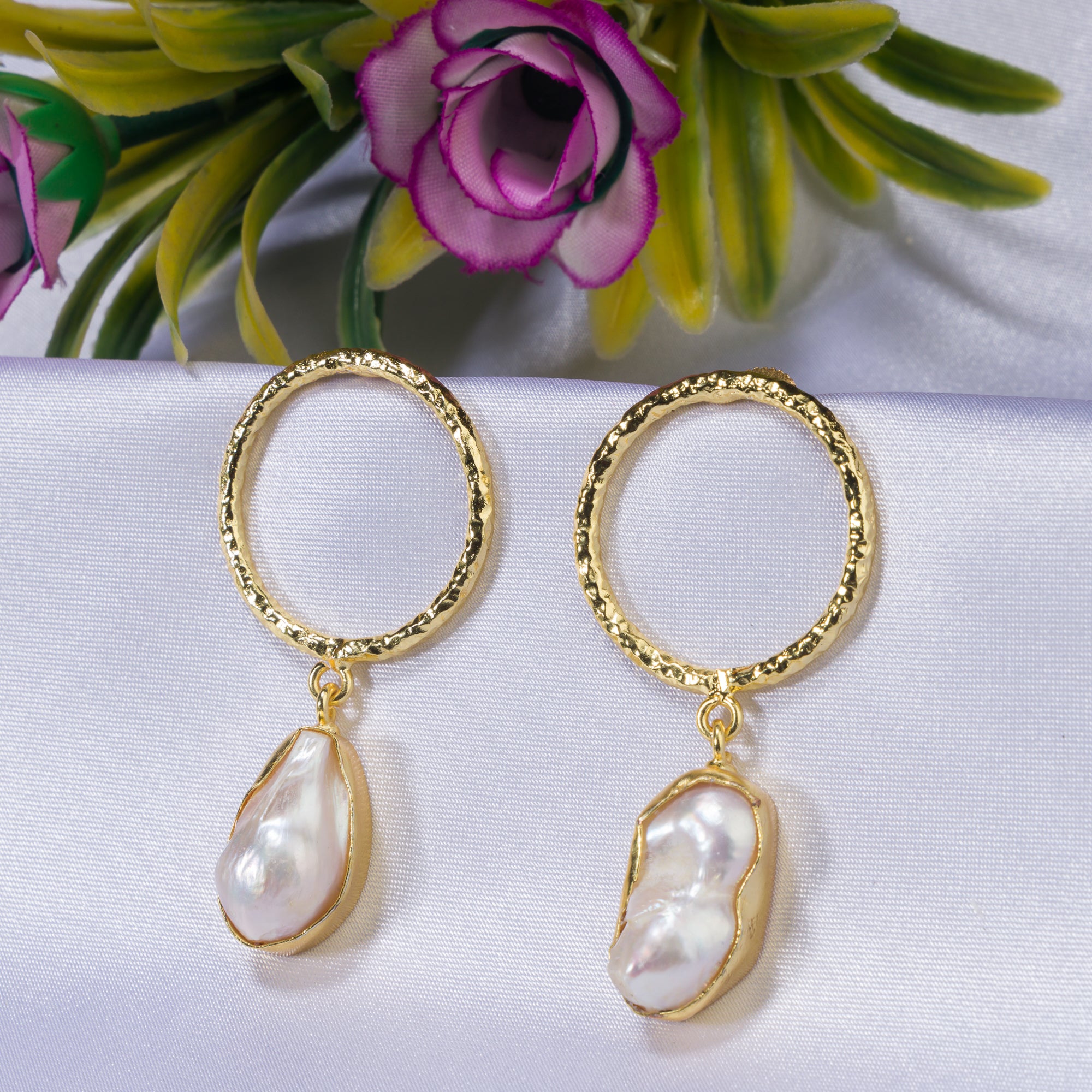 "Golden earrings with white uncut stones blend classic elegance with modern flair."