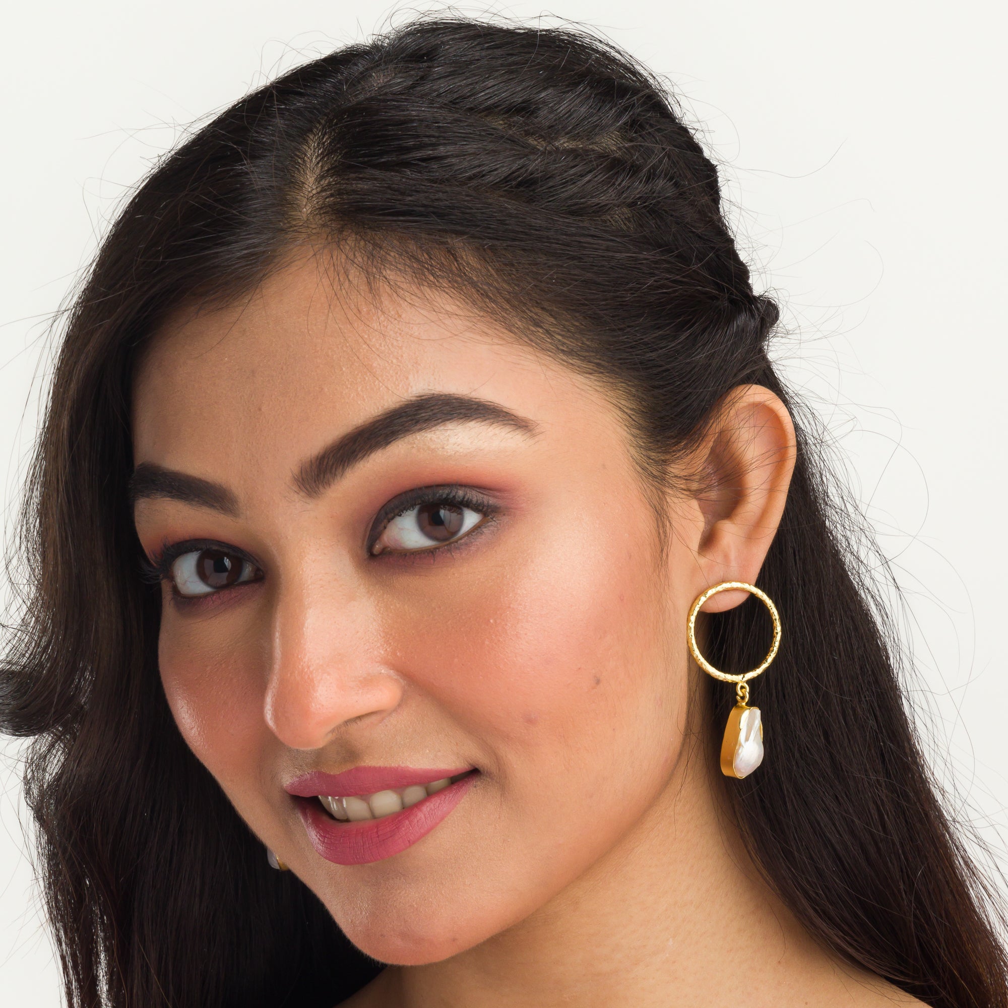 "Golden earrings with white uncut stones blend classic elegance with modern flair."