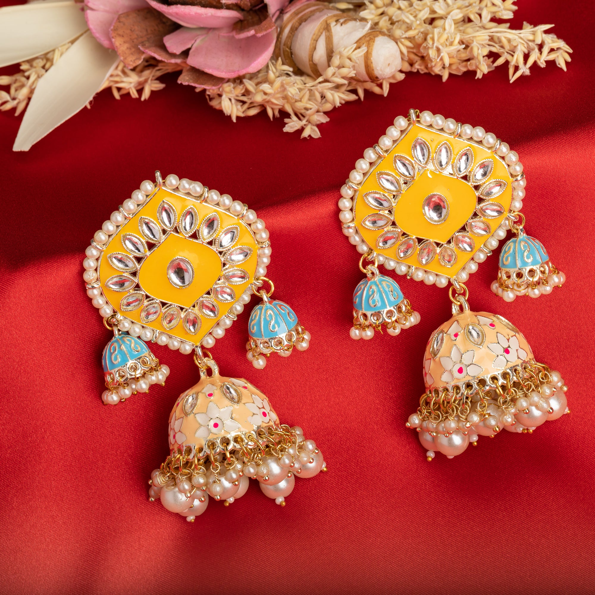 "Yellow and blue gold jhumka earrings blend bold colors with classic elegance for a striking look."