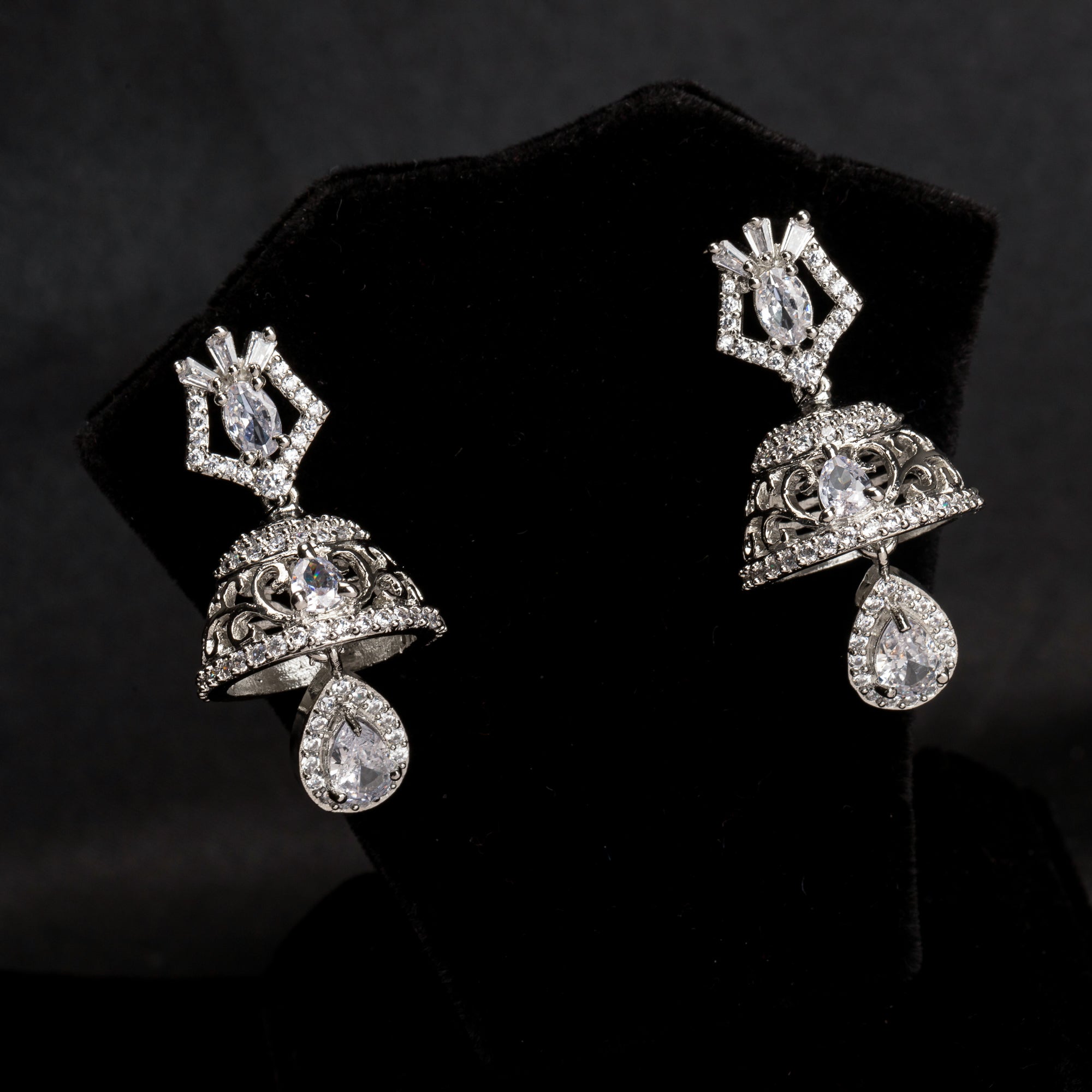 "Zircon jhumkas with intricate designs and sparkling stones create a dazzling statement."