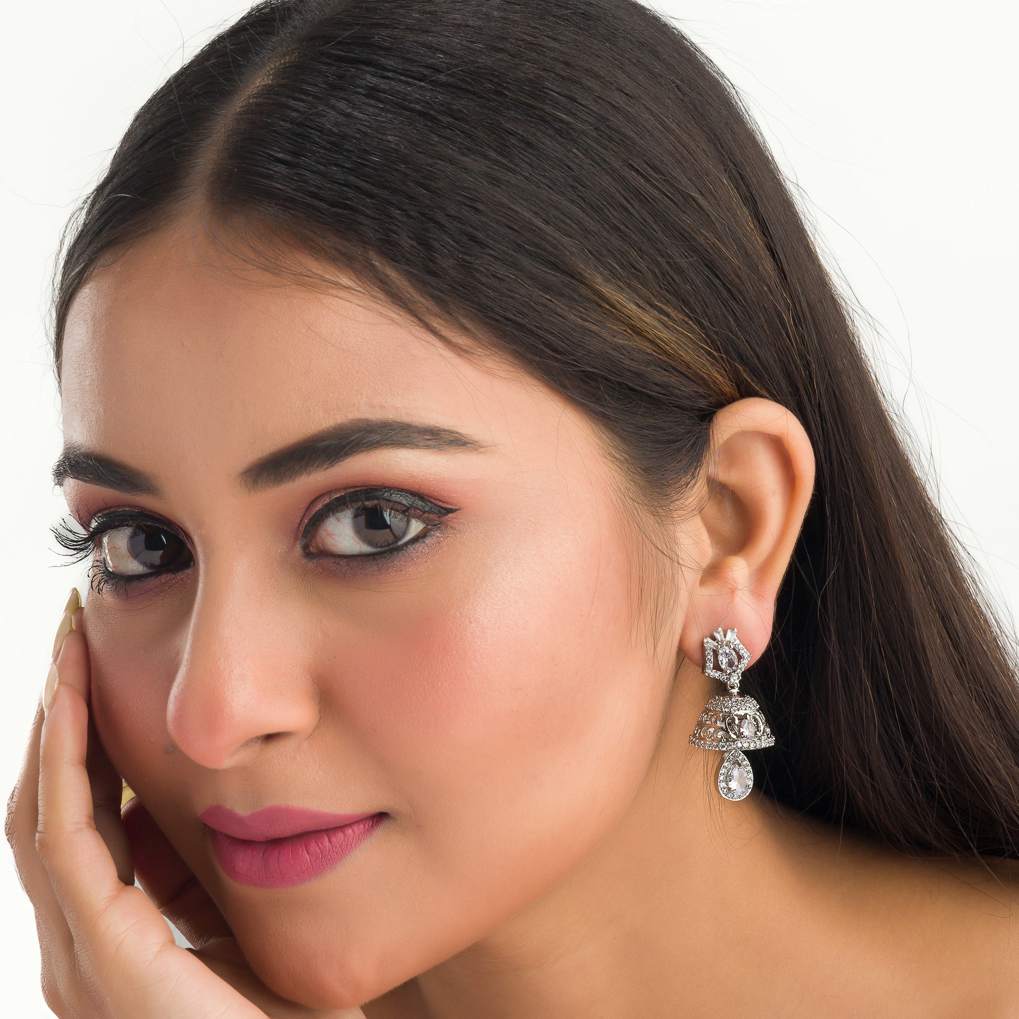 "Zircon jhumkas with intricate designs and sparkling stones create a dazzling statement."