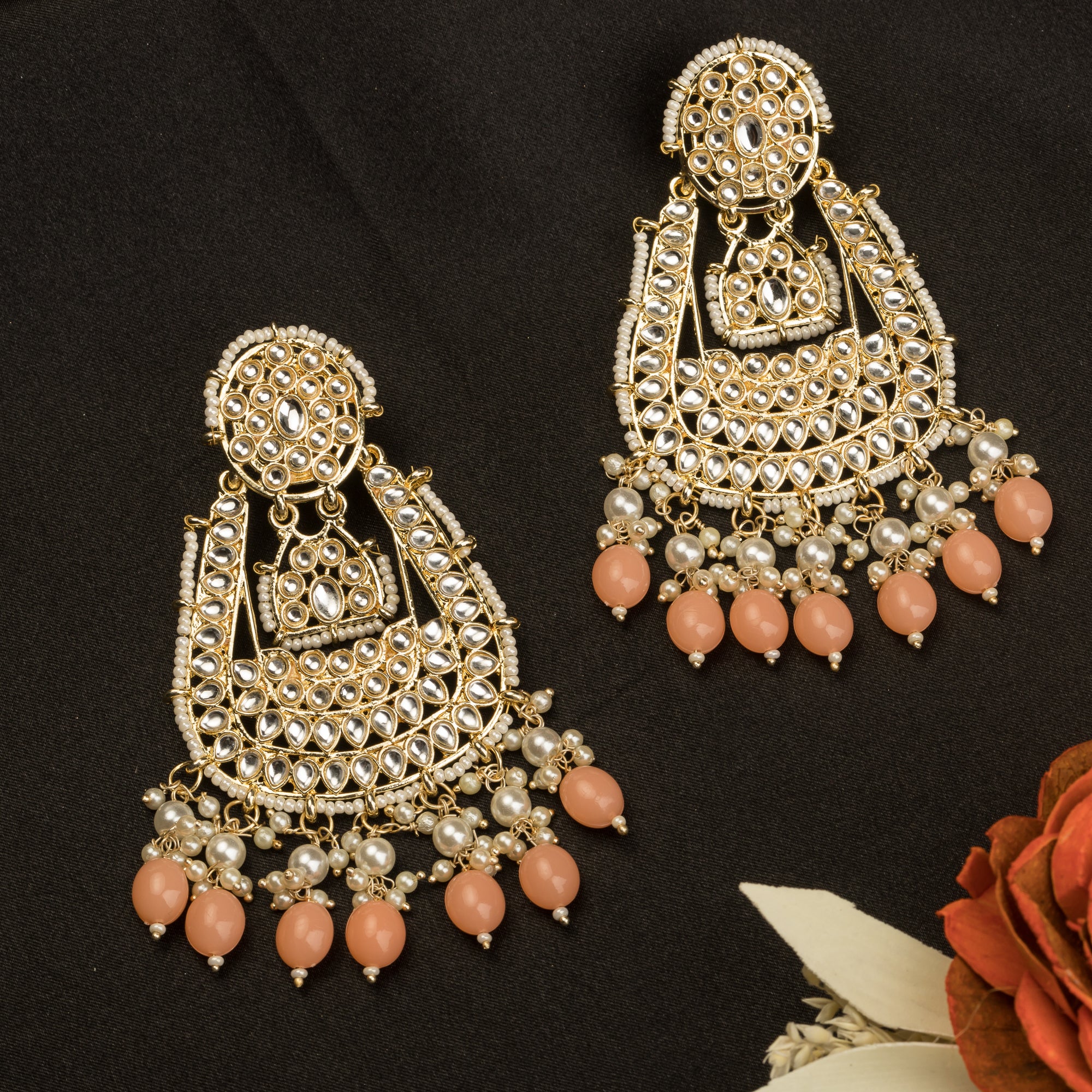 "Salmon color Kundan earrings make a bold, elegant statement for festive occasions."