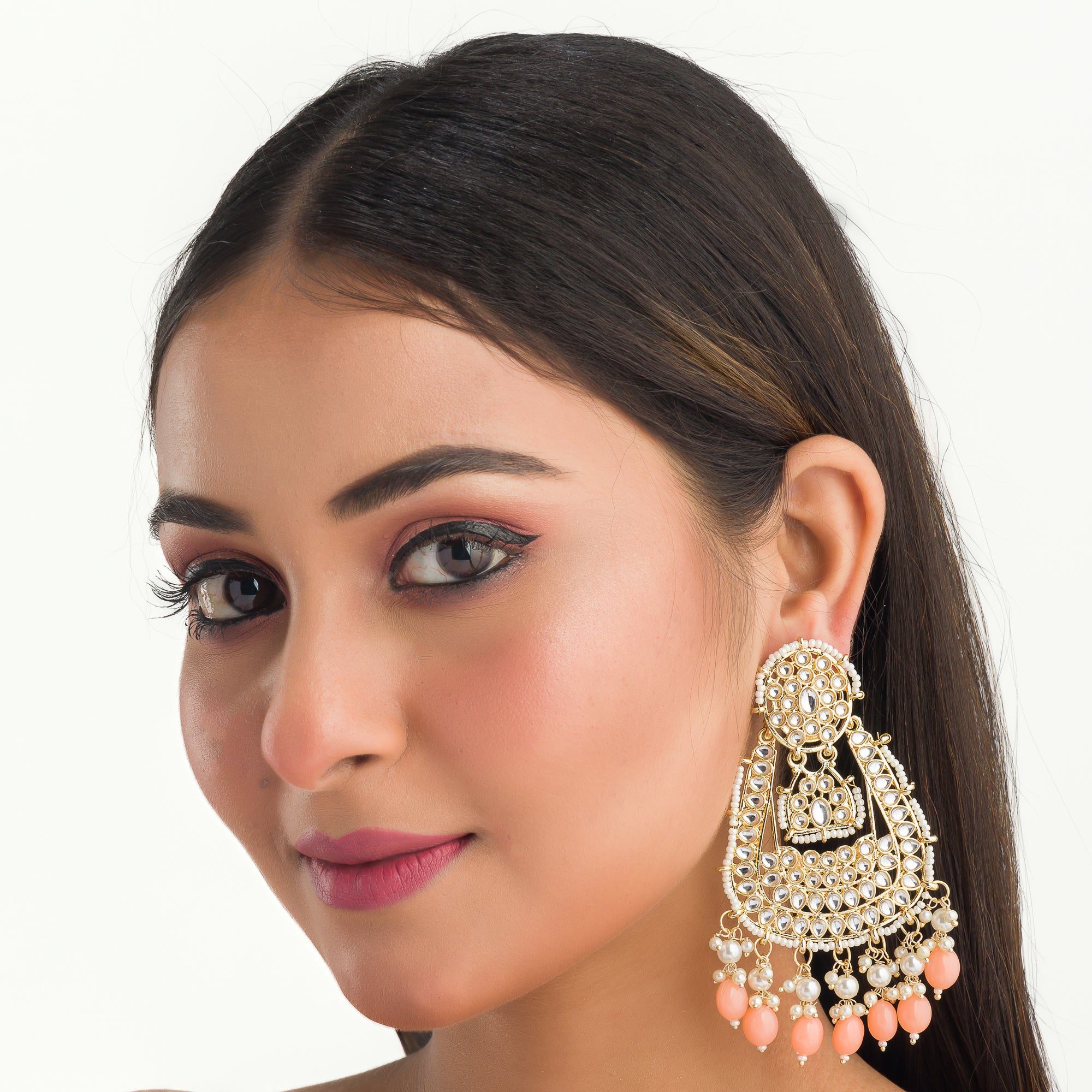 "Salmon color Kundan earrings make a bold, elegant statement for festive occasions."