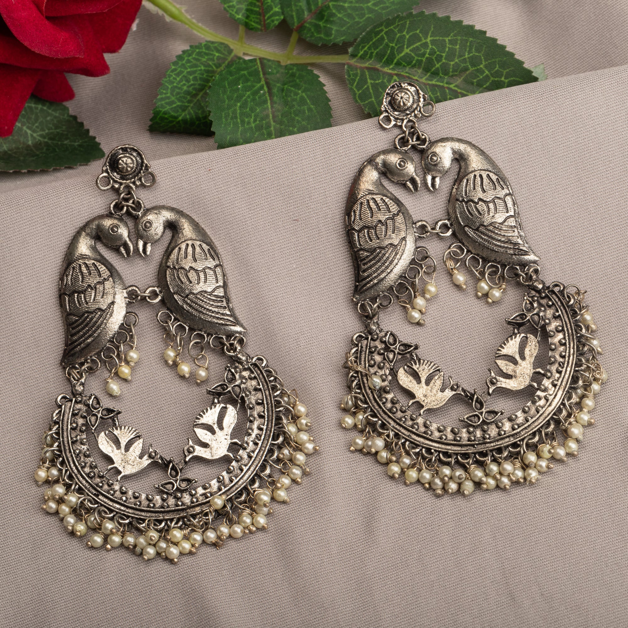 "Small oxidized earrings with two birds add vintage charm with intricate details."