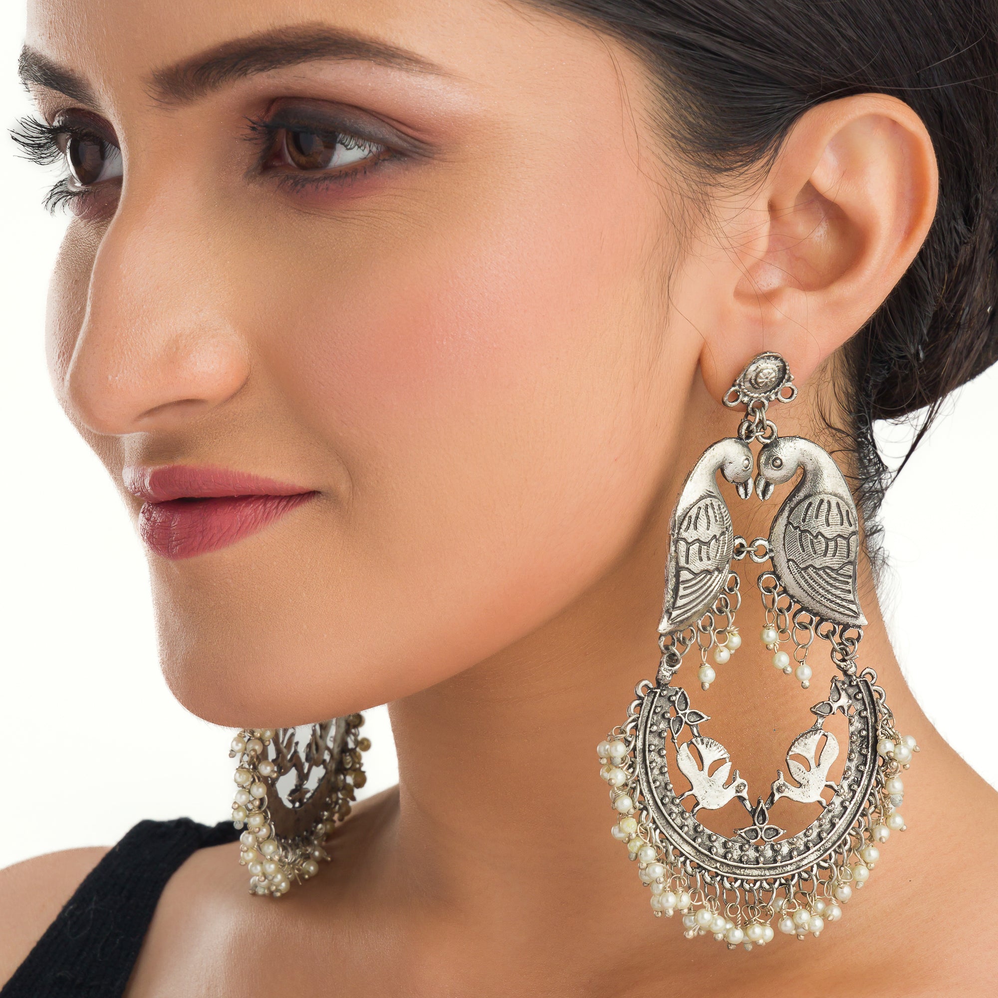 "Small oxidized earrings with two birds add vintage charm with intricate details."