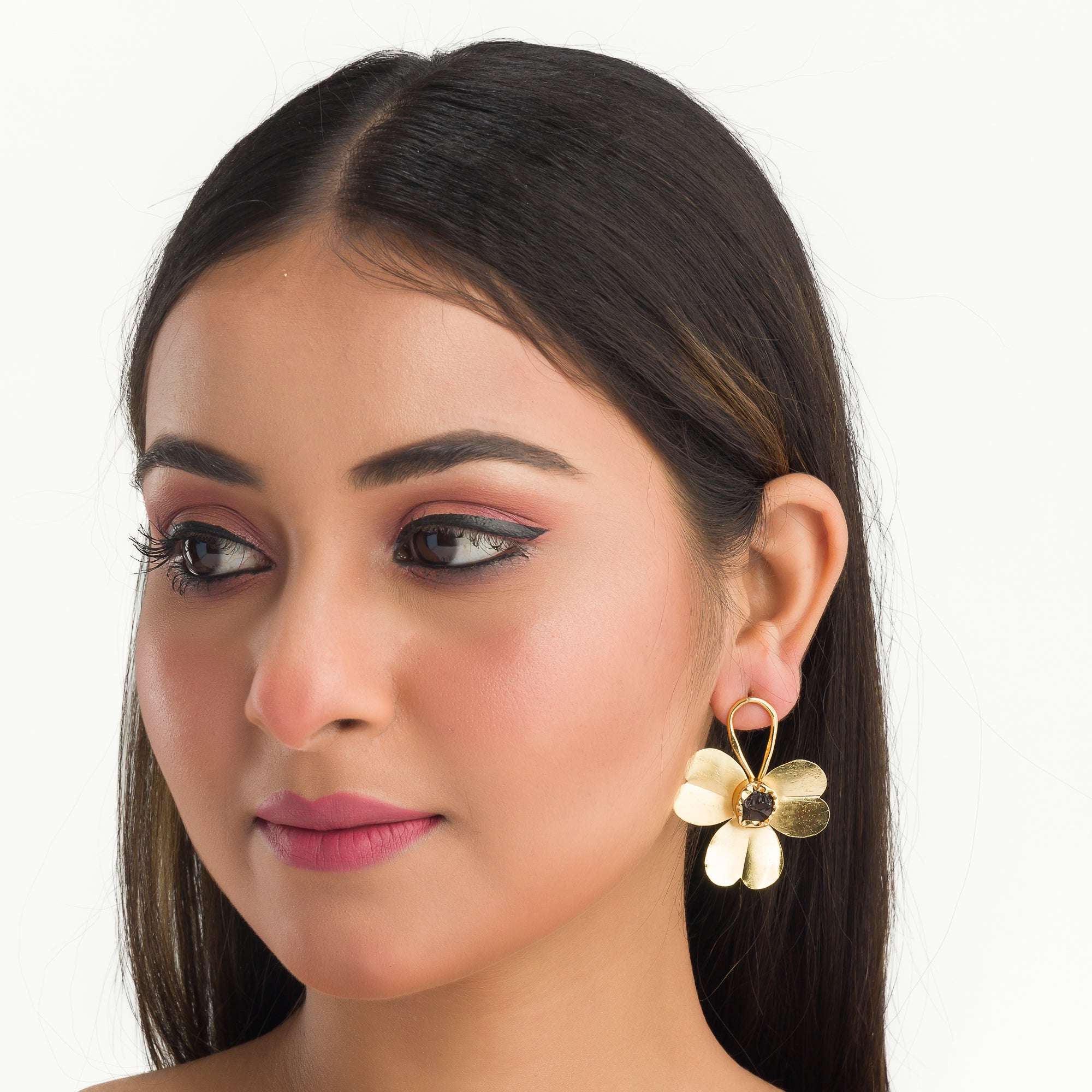 "Gold-tone flower studs with uncut stones offer timeless elegance for any occasion."