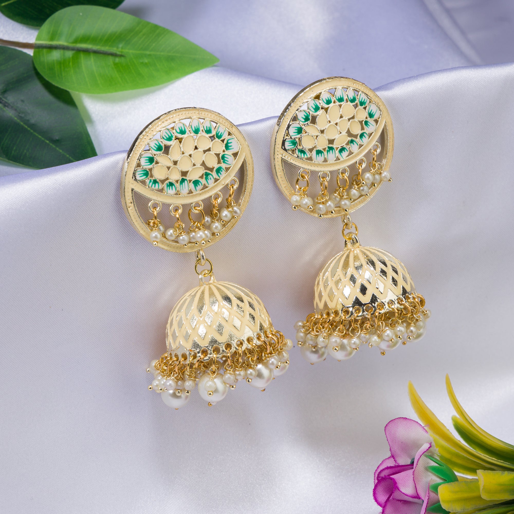 "Gold-tone jhumka with a green accent adds a vibrant twist to traditional style."