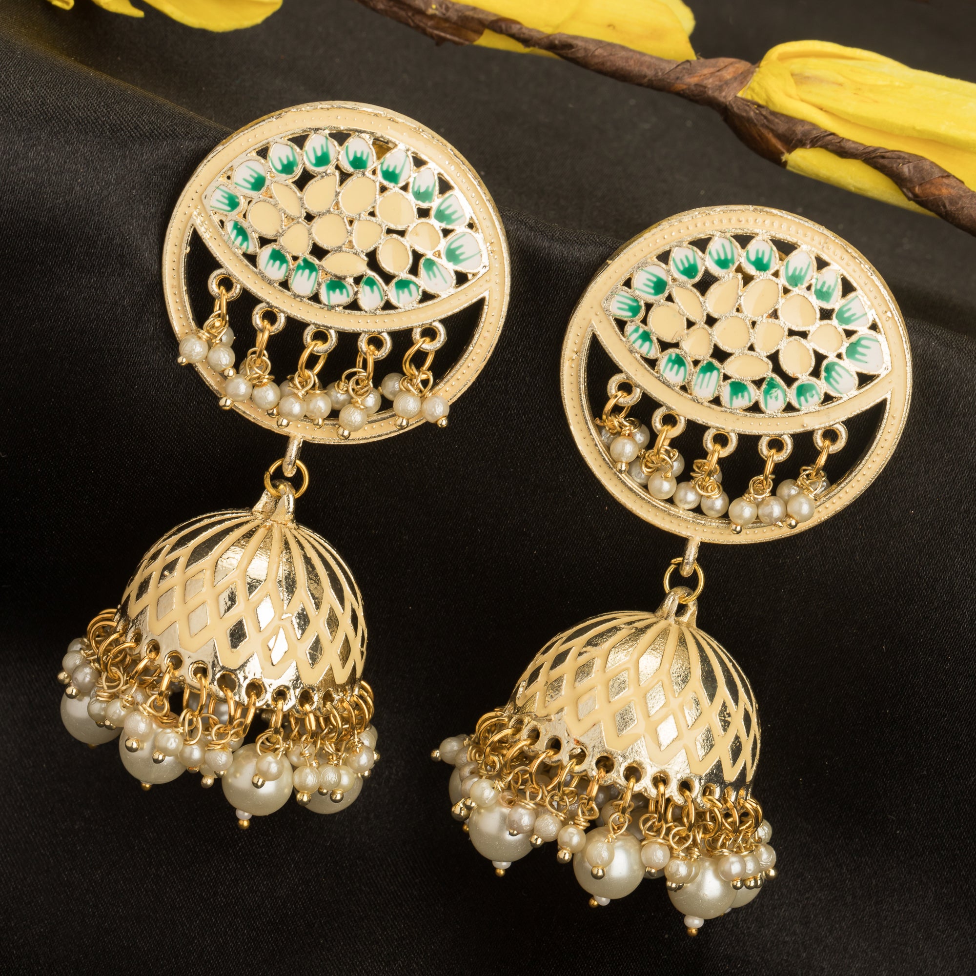 "Gold-tone jhumka with a green accent adds a vibrant twist to traditional style."
