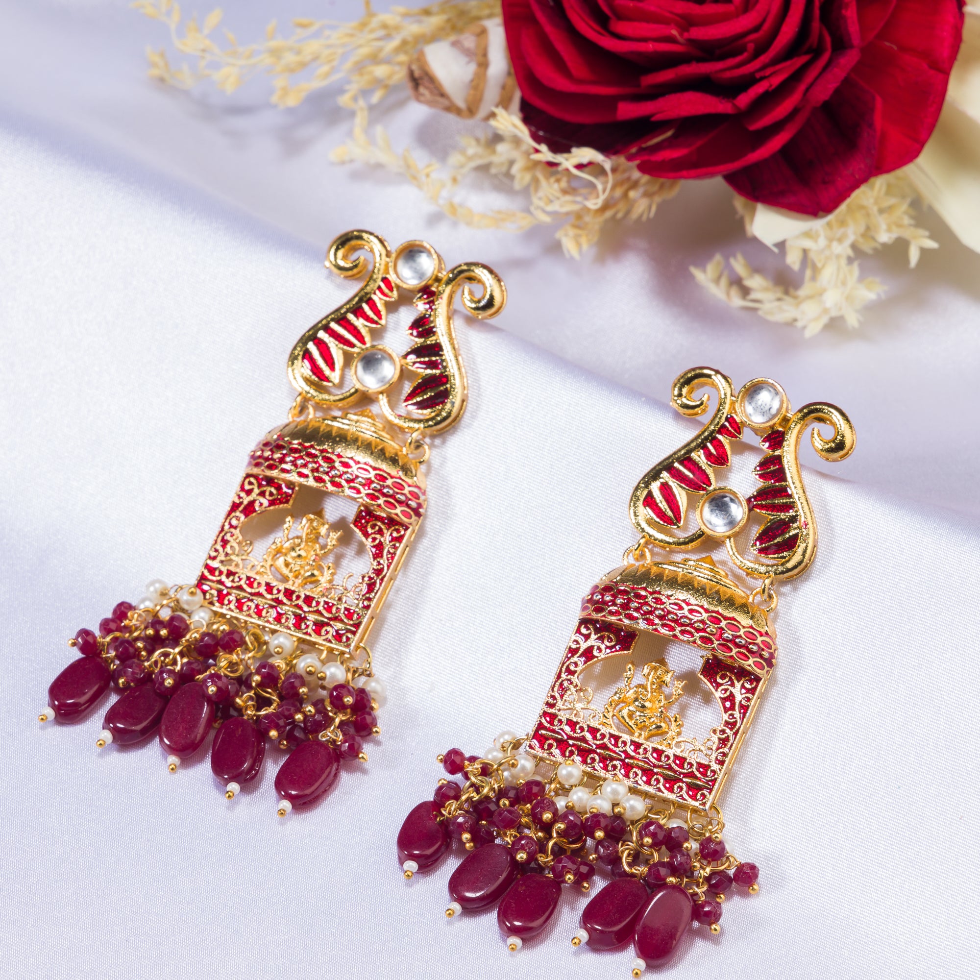 "Ganesh idol earrings with kundan and gold-tone polish add classic charm and grace."