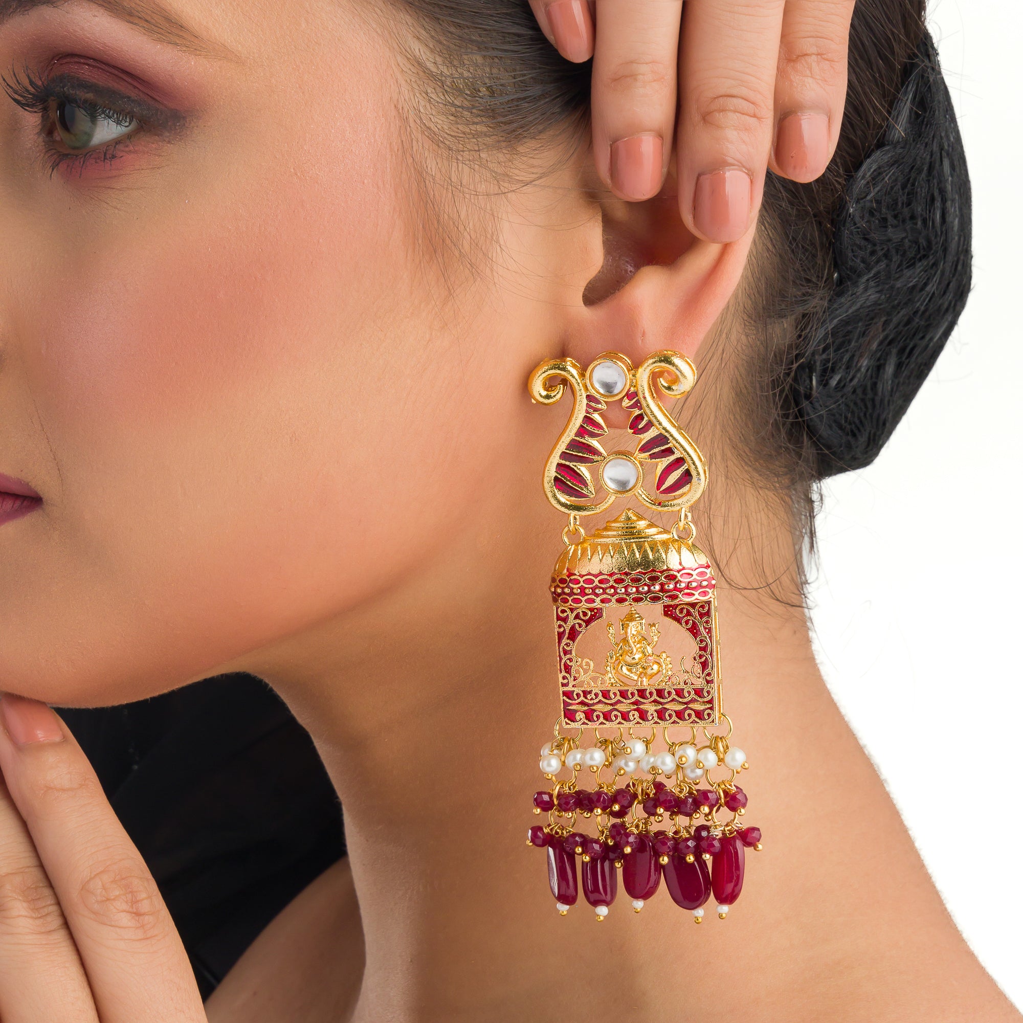 "Ganesh idol earrings with kundan and gold-tone polish add classic charm and grace."