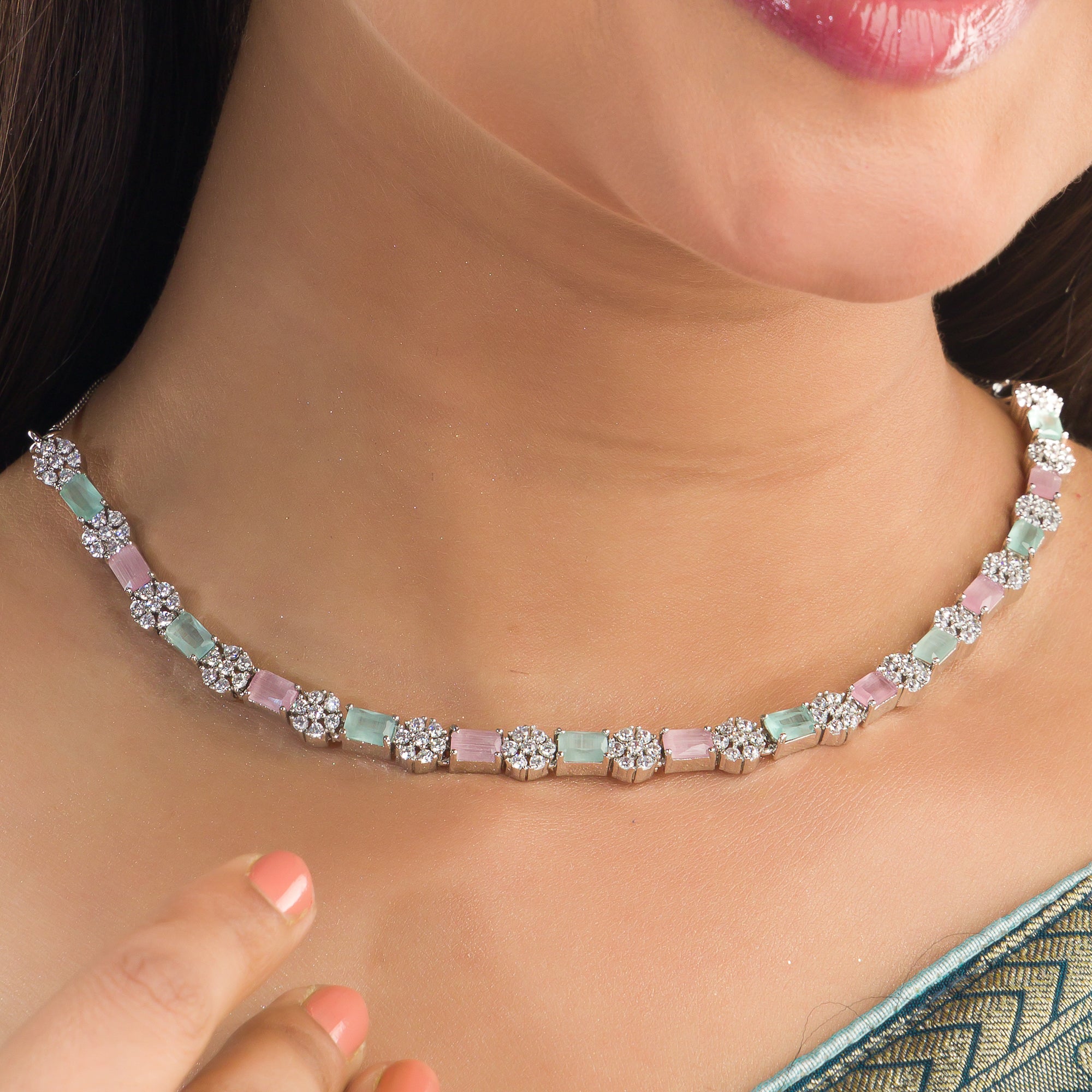 "Zircon silver necklace with pink and green accents adds a delicate, colorful touch."
