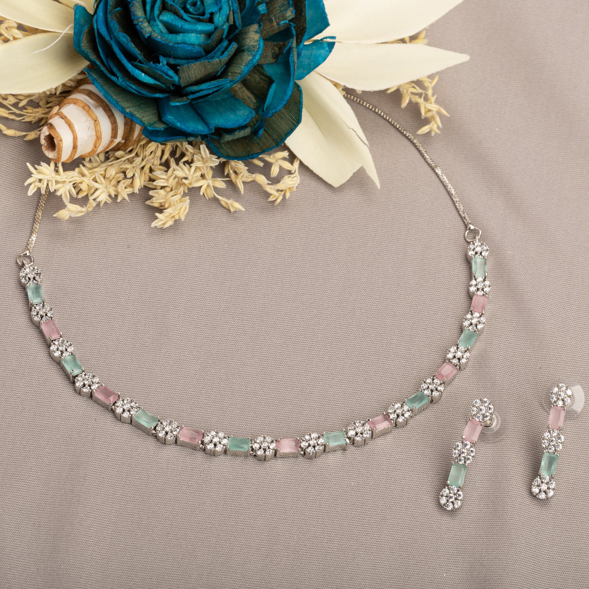 "Zircon silver necklace with pink and green accents adds a delicate, colorful touch."