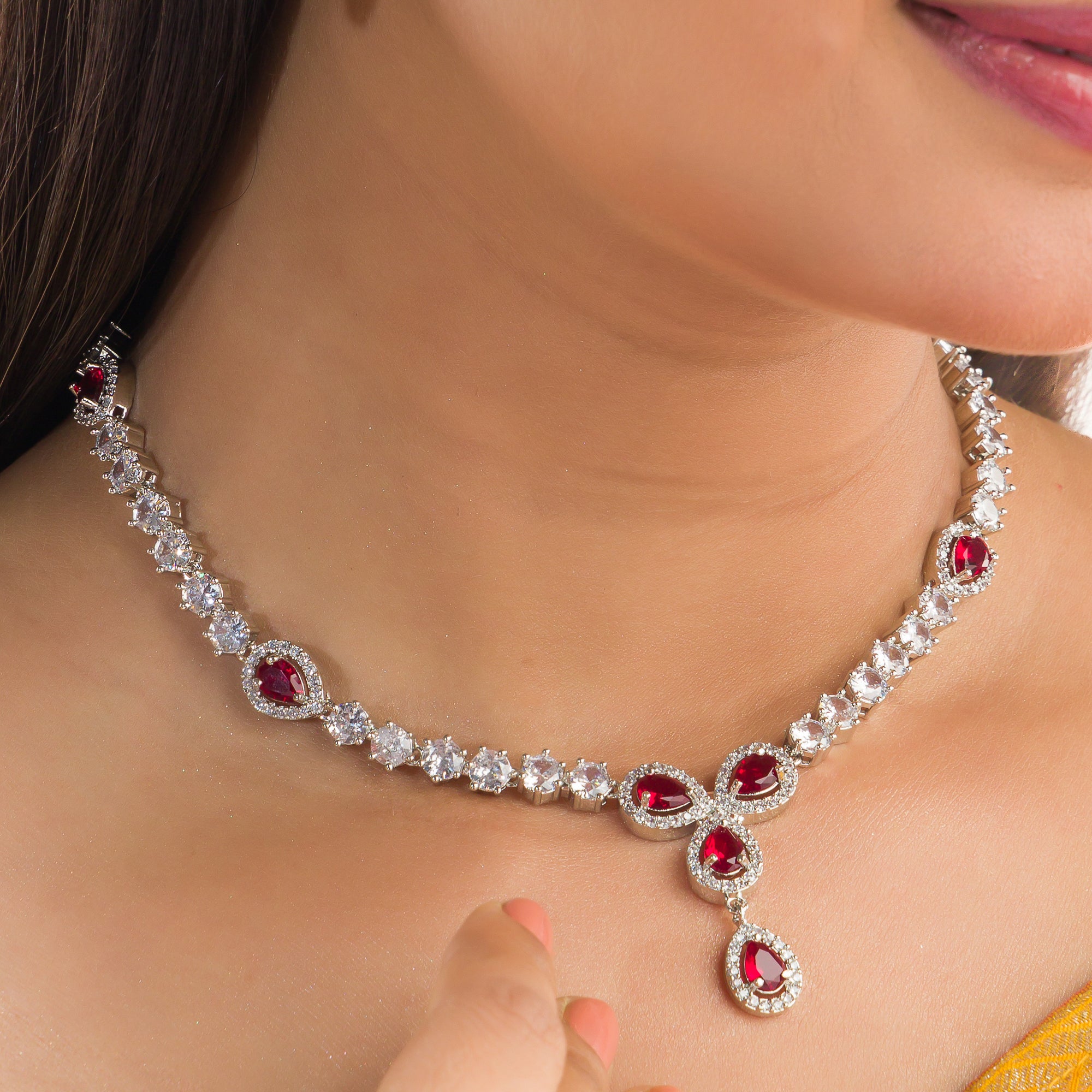 "Silver zircon necklace with maroon stone offers sophisticated, striking contrast."