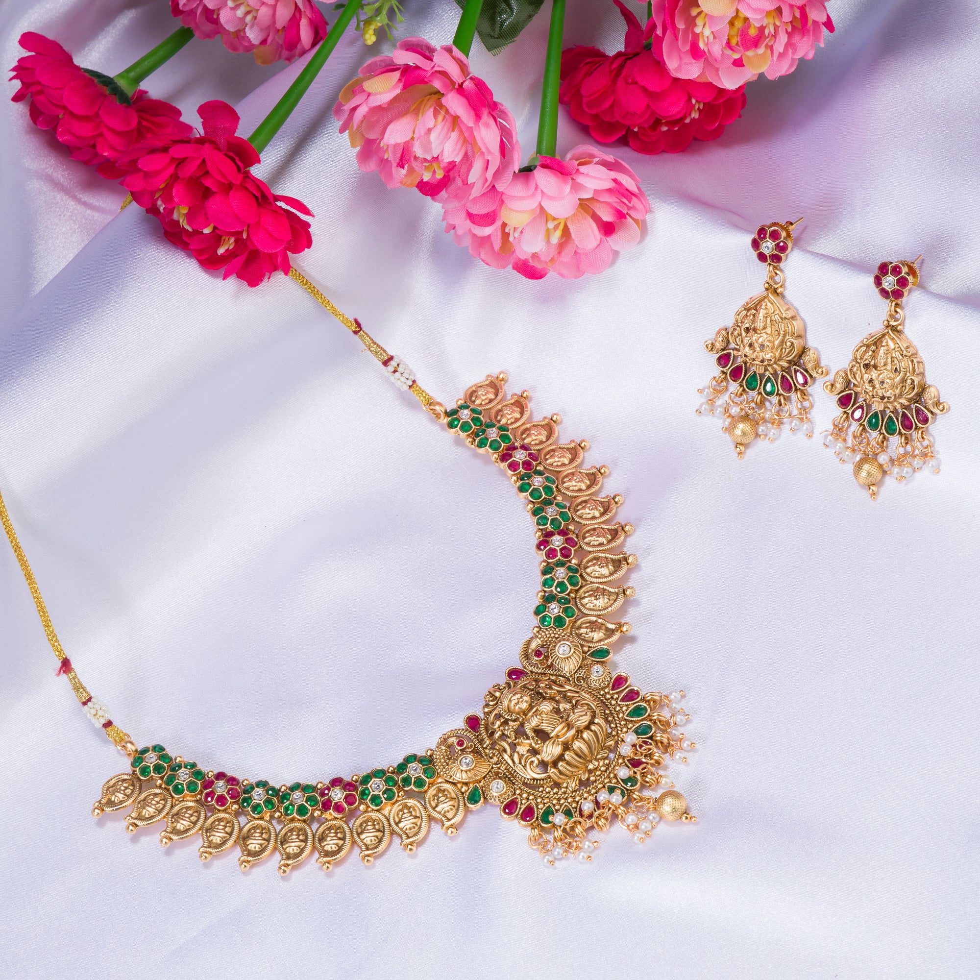 Intricate temple jewelry in red, gold, and green brings classic elegance to festival occasions.