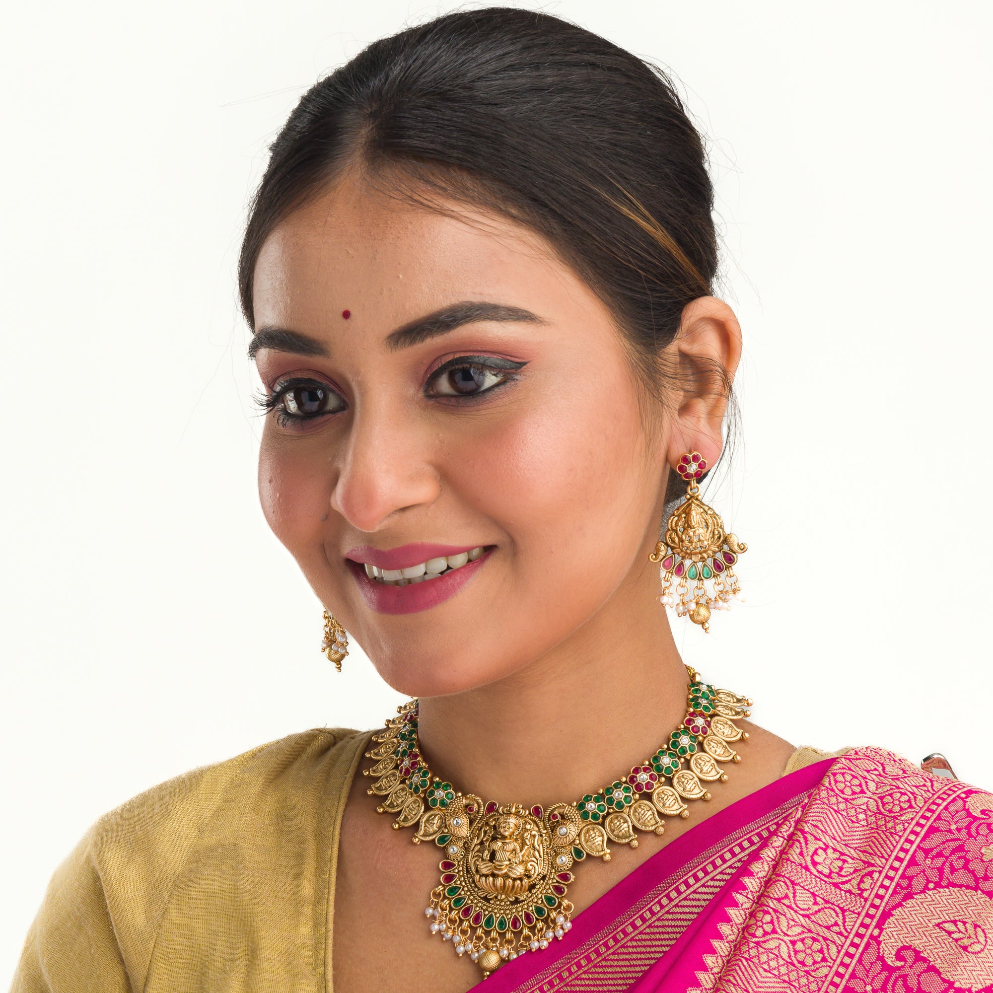 Intricate temple jewelry in red, gold, and green brings classic elegance to festival occasions.