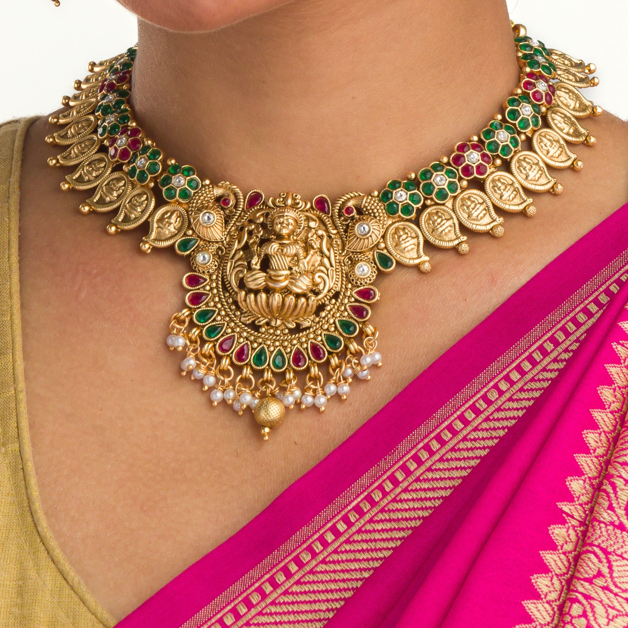 Intricate temple jewelry in red, gold, and green brings classic elegance to festival occasions.