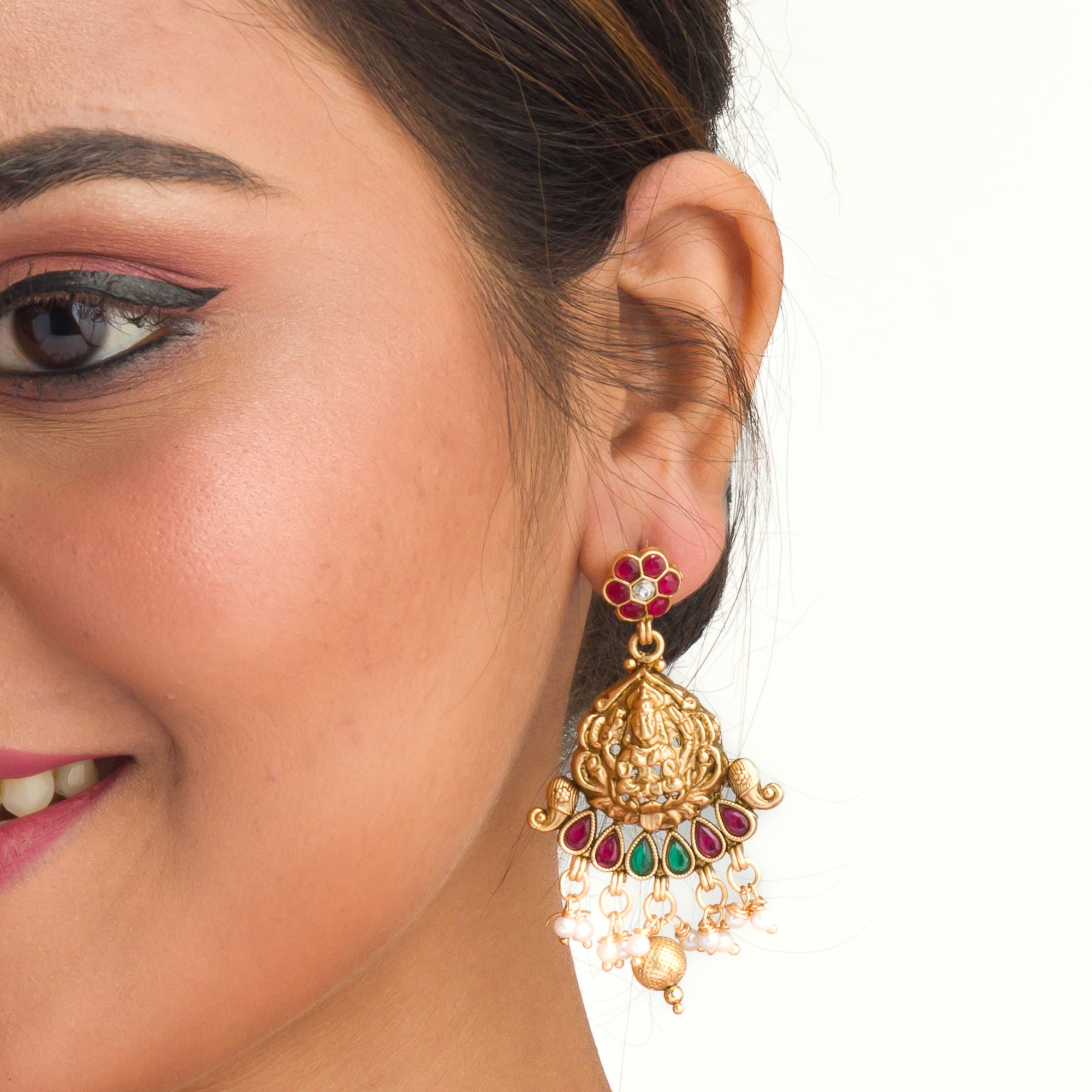 Intricate temple jewelry in red, gold, and green brings classic elegance to festival occasions.