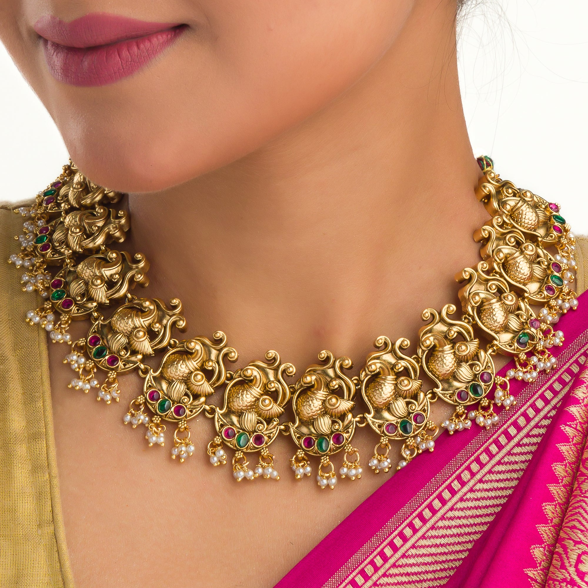 Vibrant gold-tone necklace with red, green stones, and white pearls for a stunning party look.
