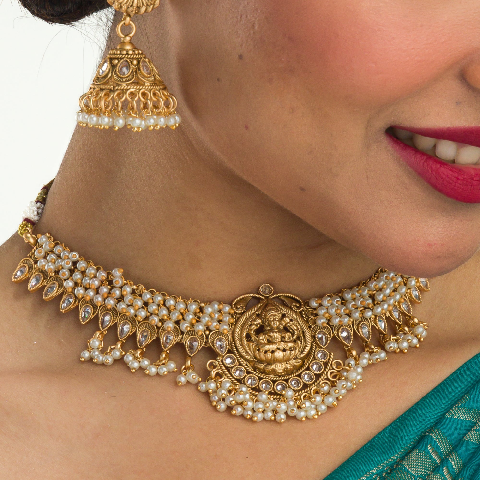 Graceful temple necklace with white pearls adds a touch of classic festival sophistication.