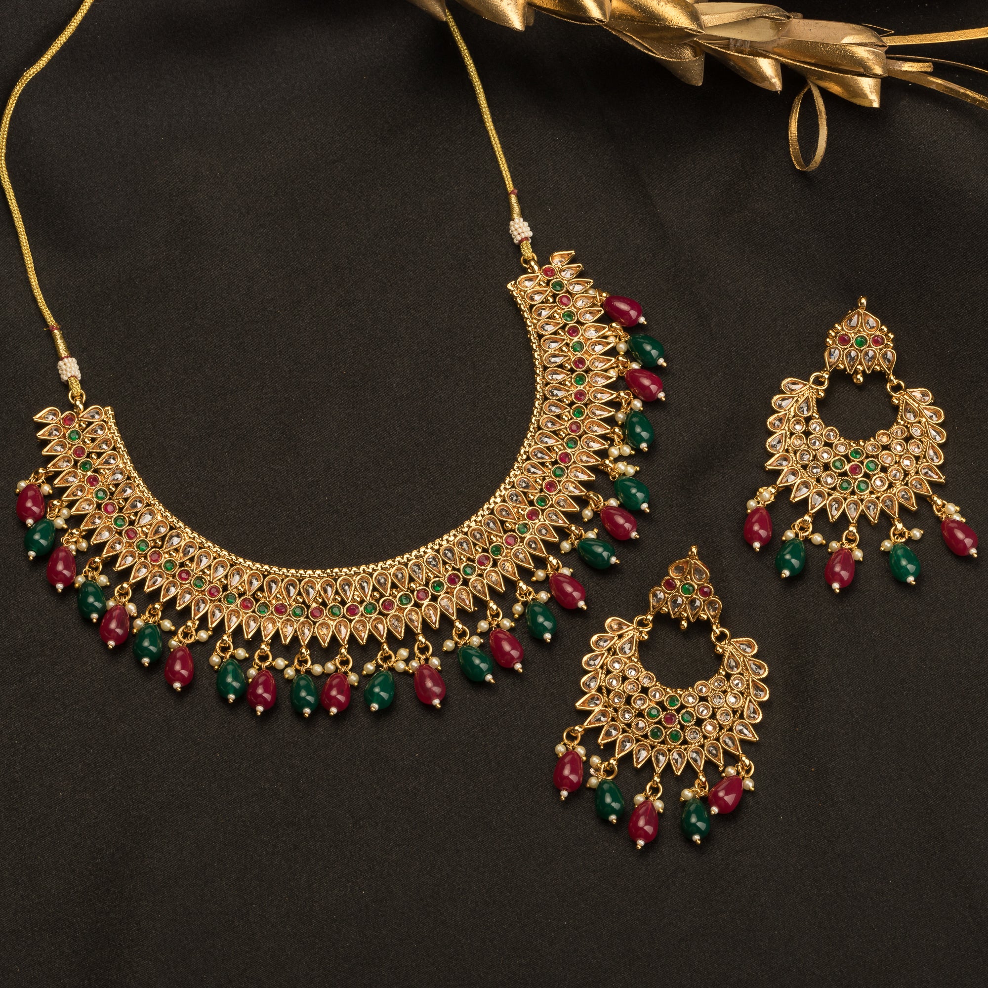 Kundan choker with maroon and green stones offers a regal and vibrant festival look.