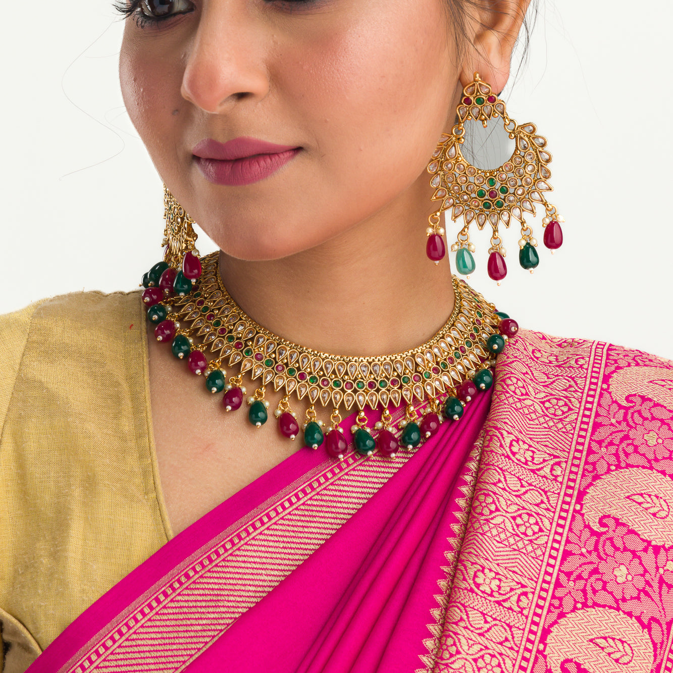 Kundan choker with maroon and green stones offers a regal and vibrant festival look.