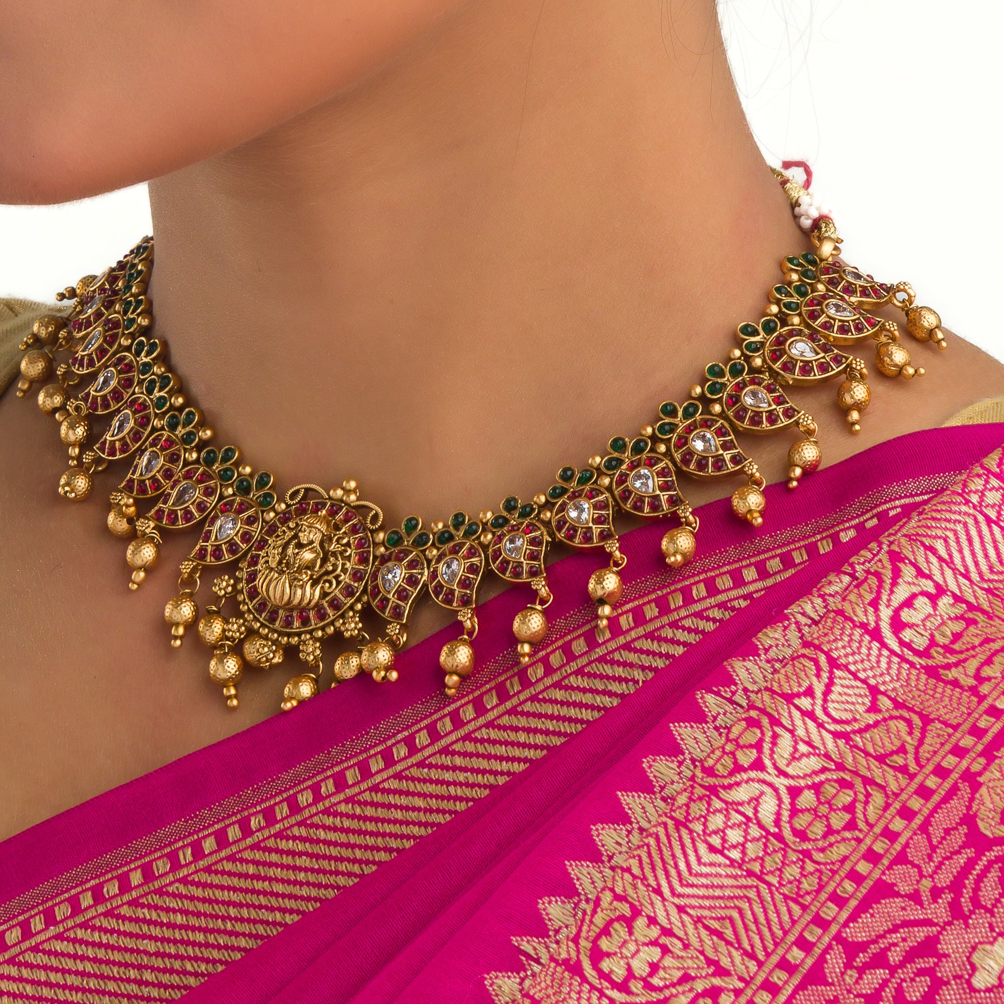Gold long necklace with multi-color stones exudes vibrant elegance for a festive celebration.
